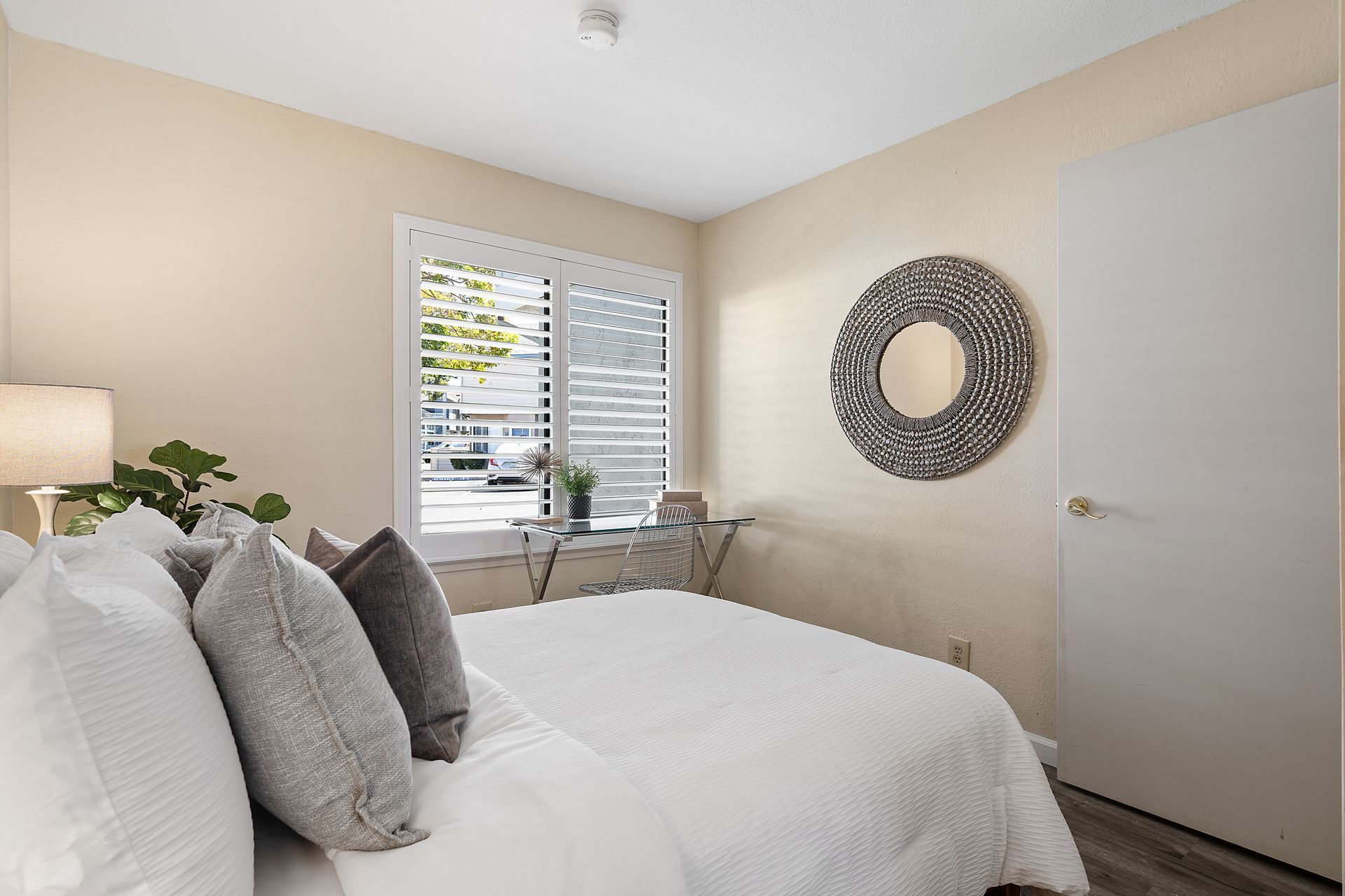 A bedroom with a large bed and a mirror on the wall