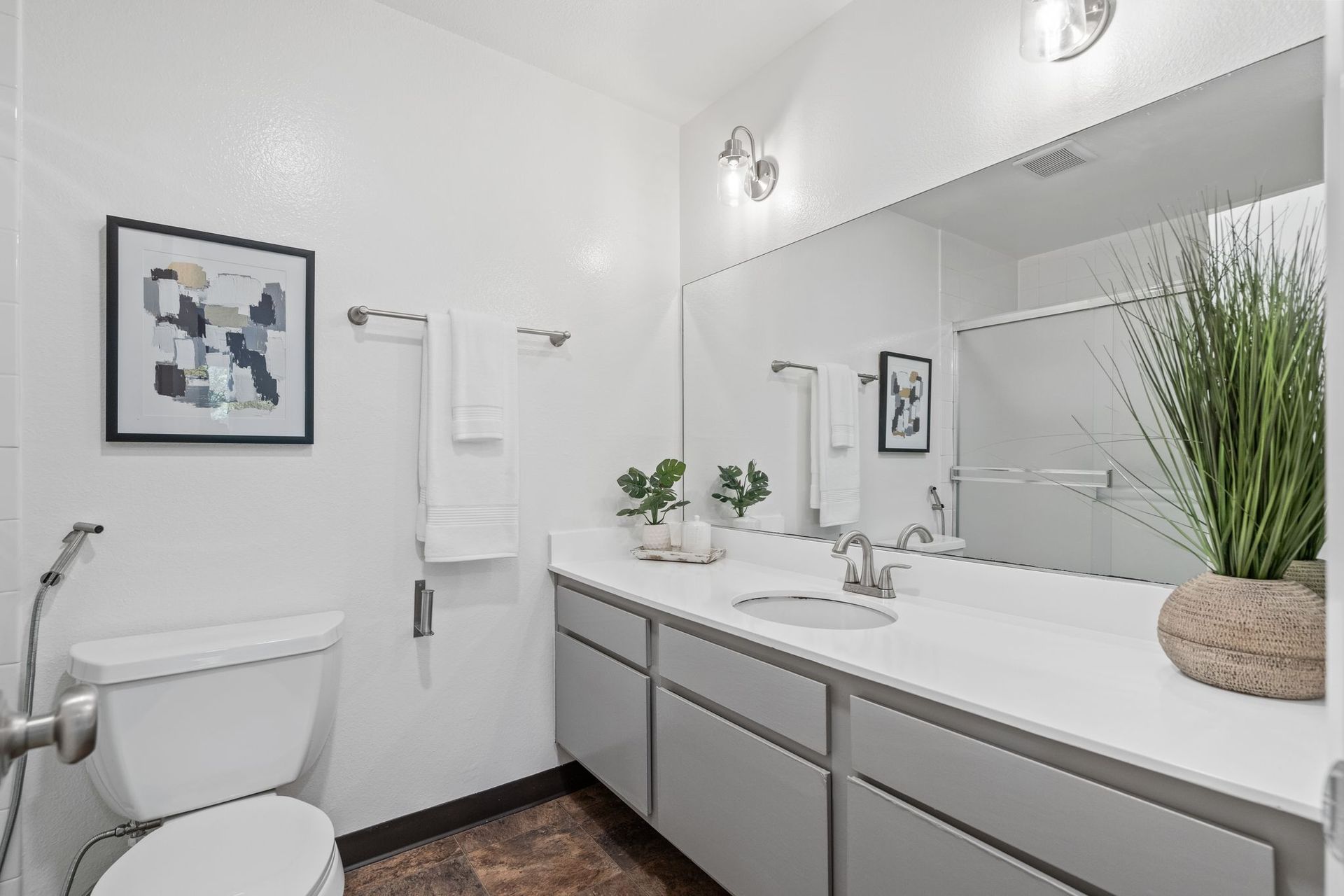 A bathroom with a toilet , sink , and mirror.