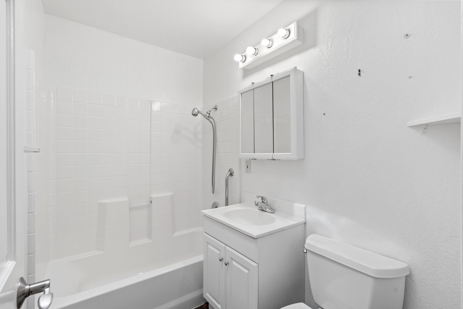 A bathroom with a toilet , sink , bathtub and shower.