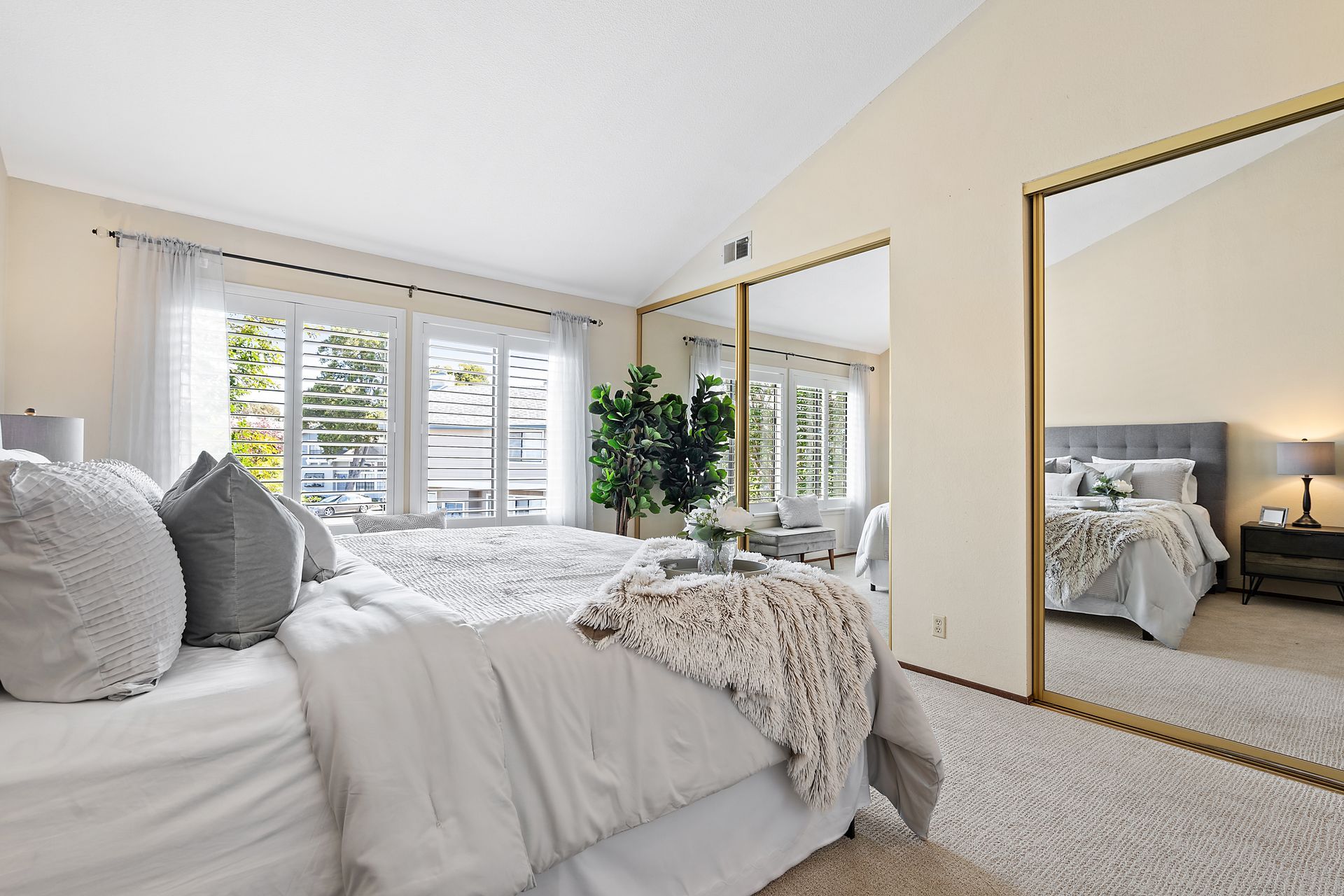 A bedroom with a large bed and a large mirror.