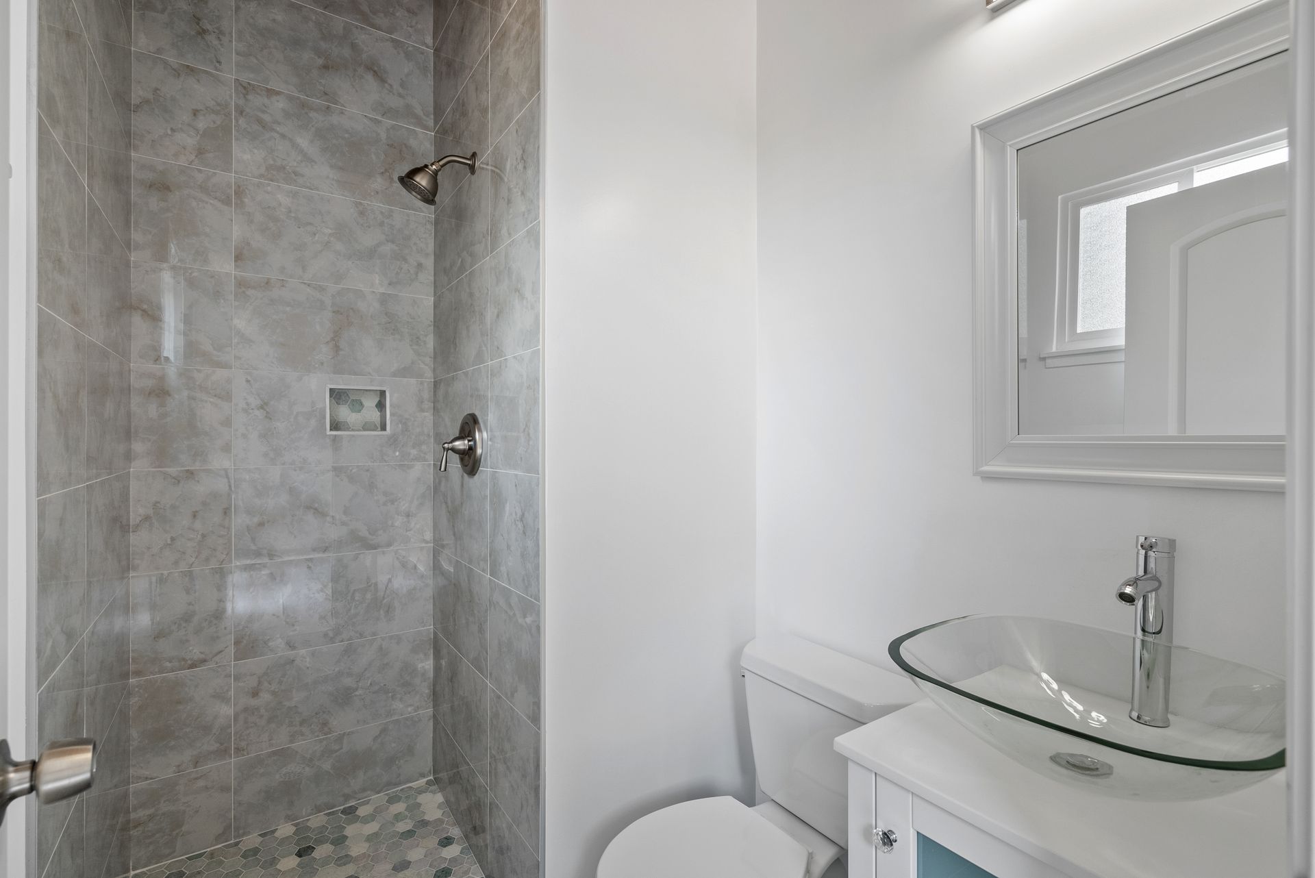 A bathroom with a toilet , sink and shower.