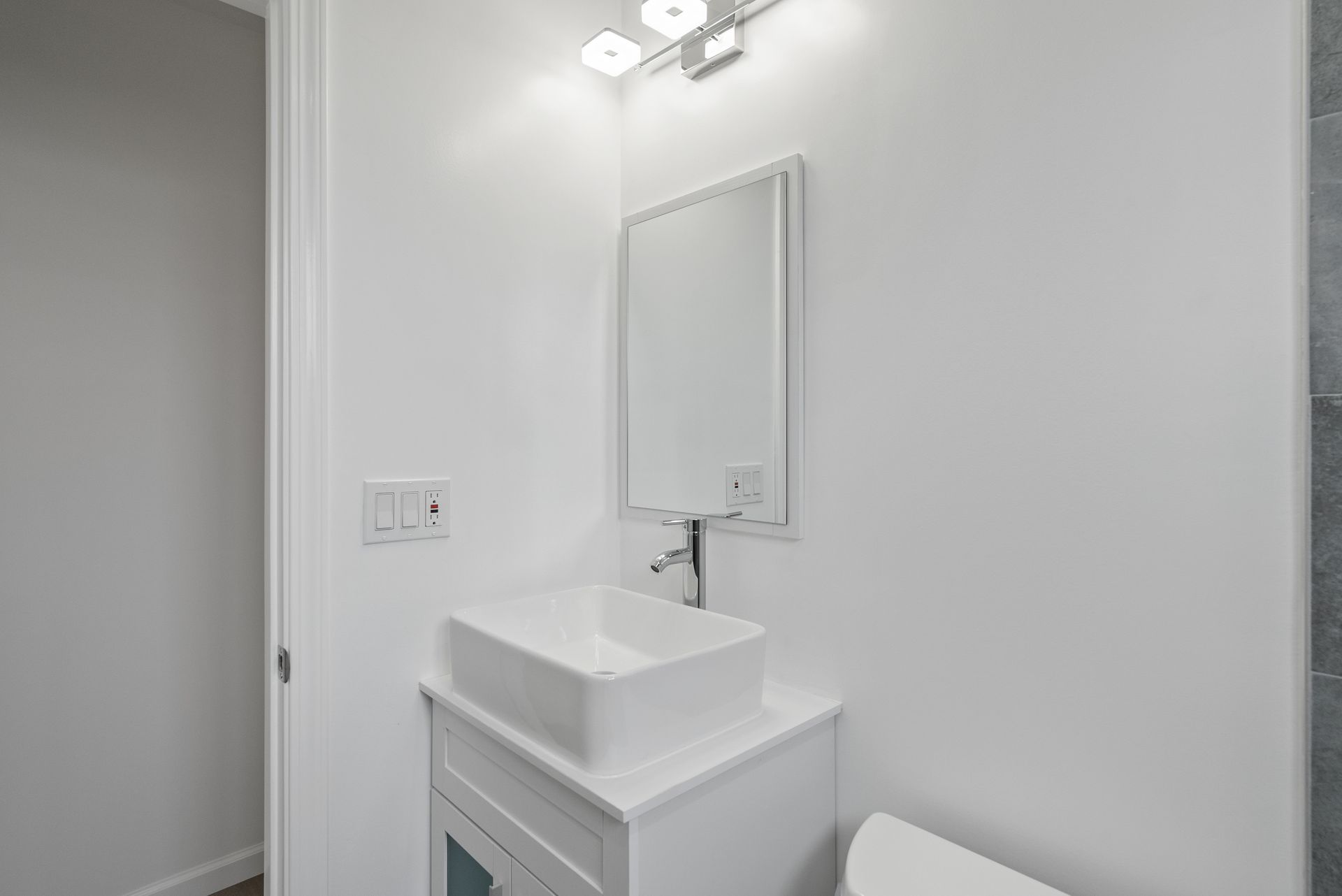 A bathroom with a sink , mirror and toilet.