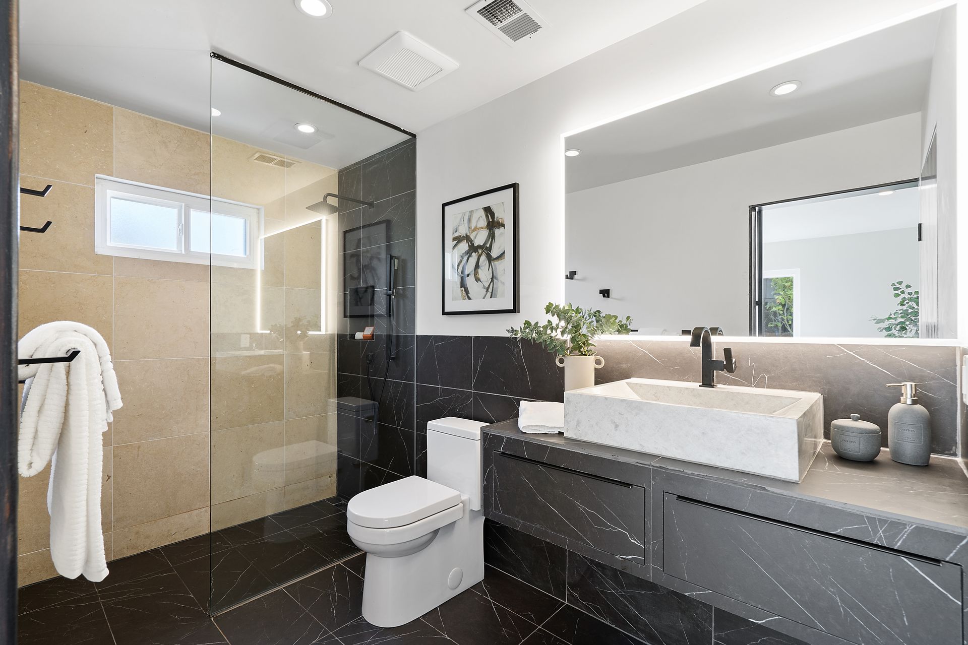 A bathroom with a toilet a sink and a mirror