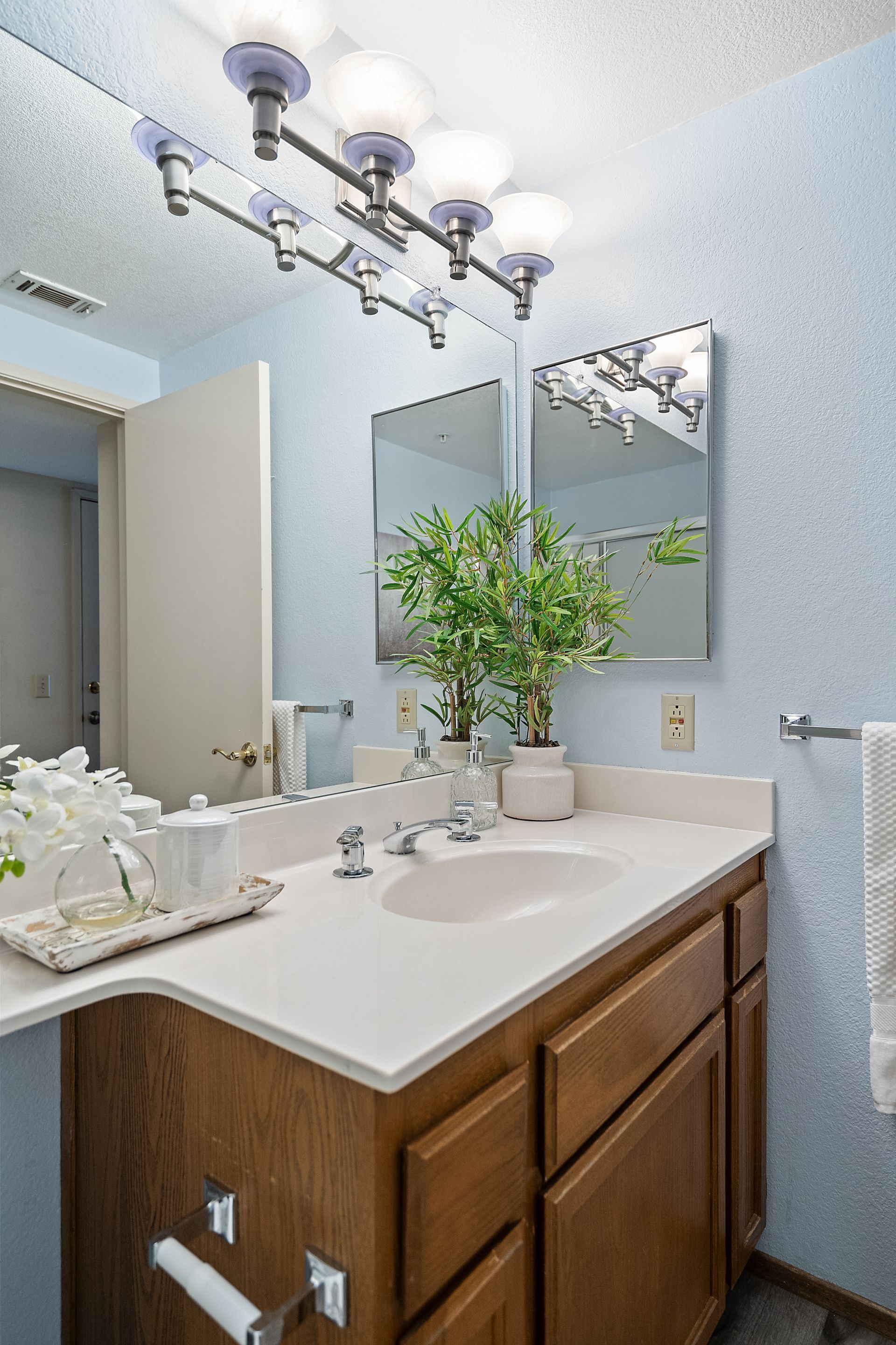 A bathroom with a sink , mirror and light fixture.