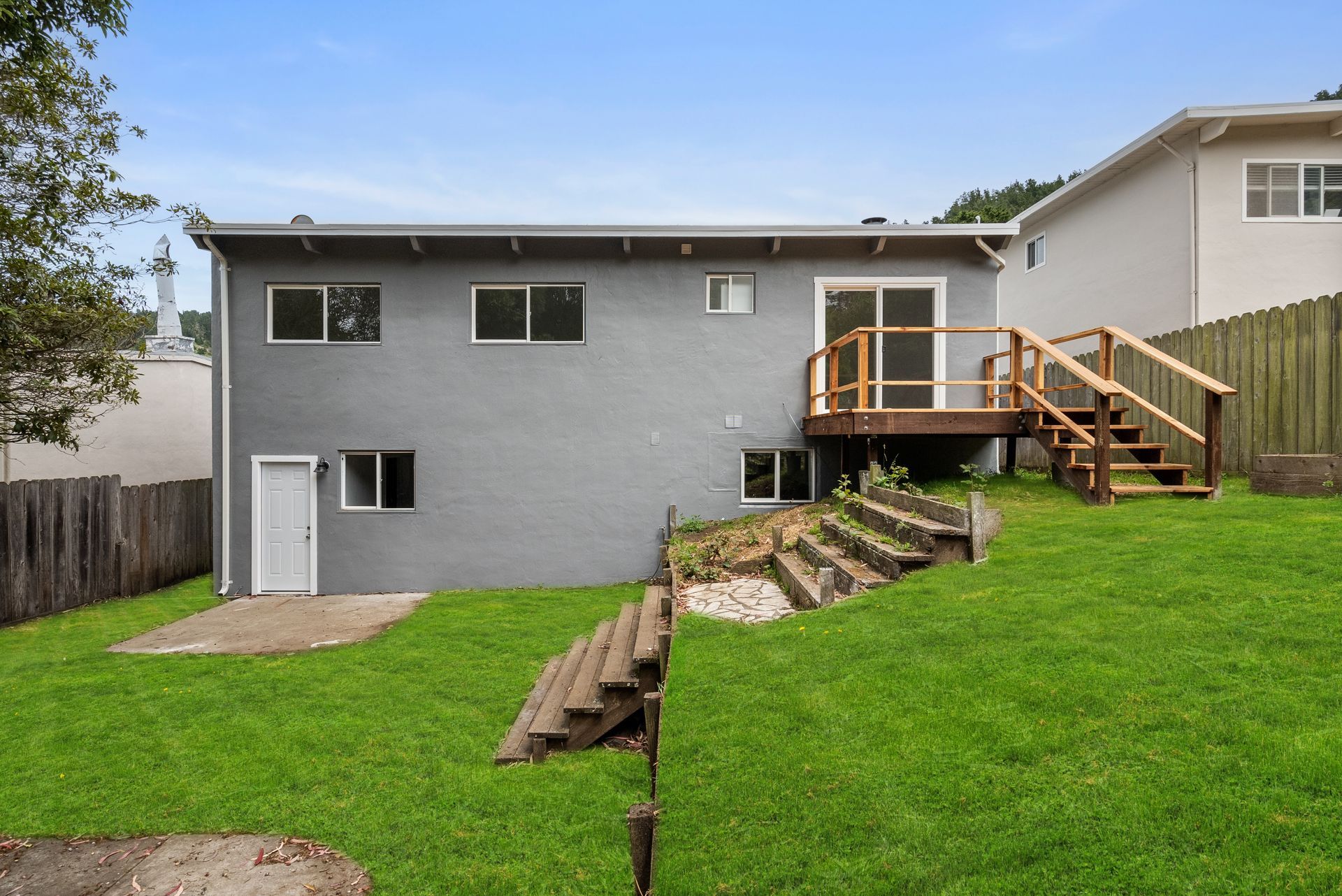 A house with a deck and stairs in the backyard.