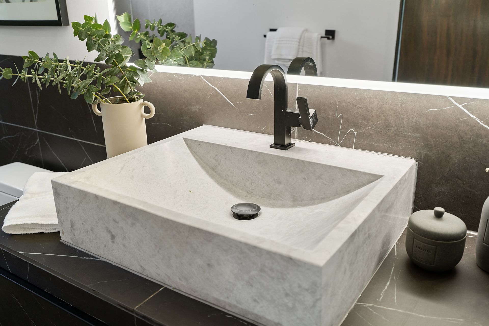 A bathroom with a marble sink and a mirror.