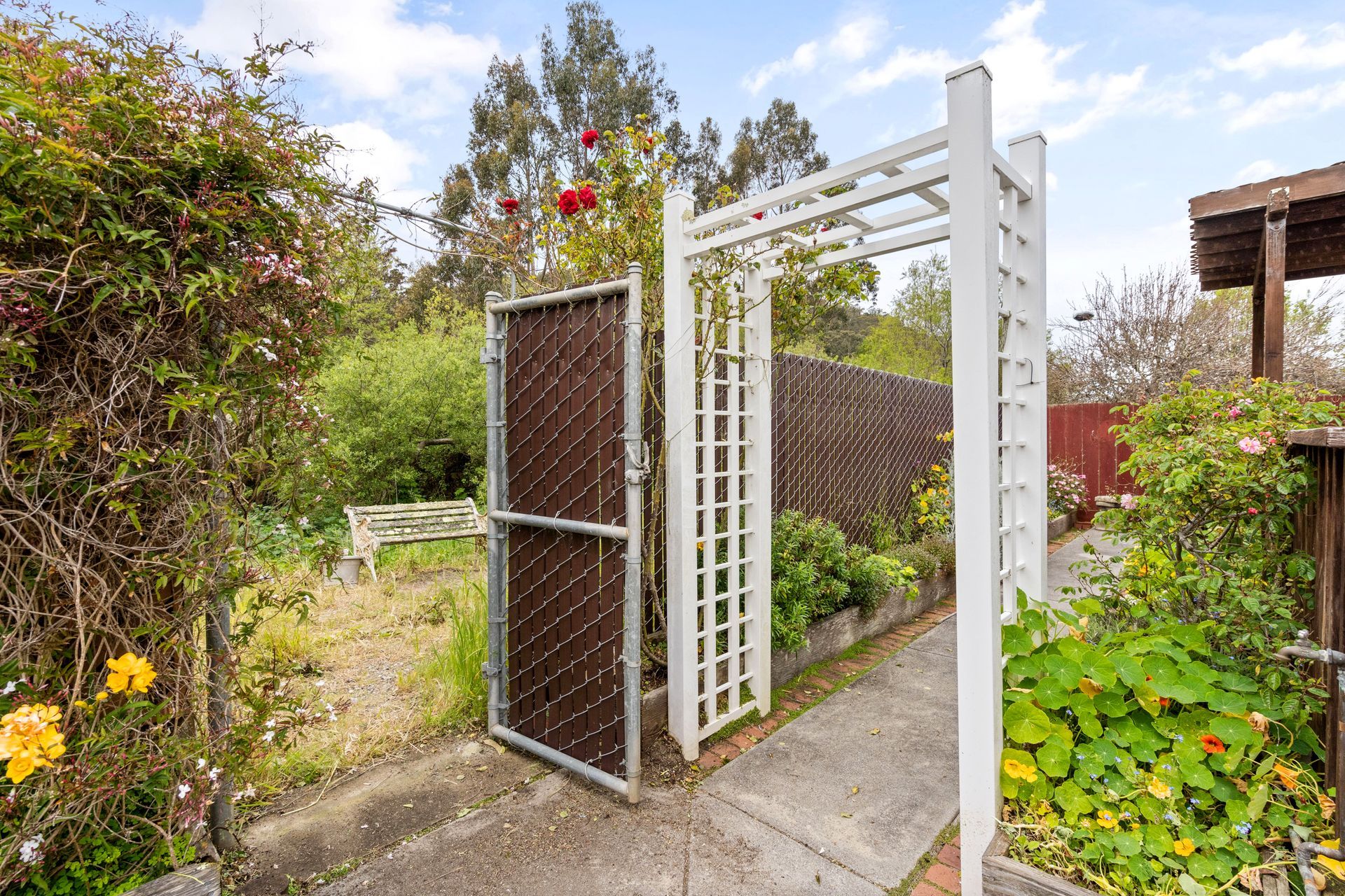 There is a gate in the middle of a garden.