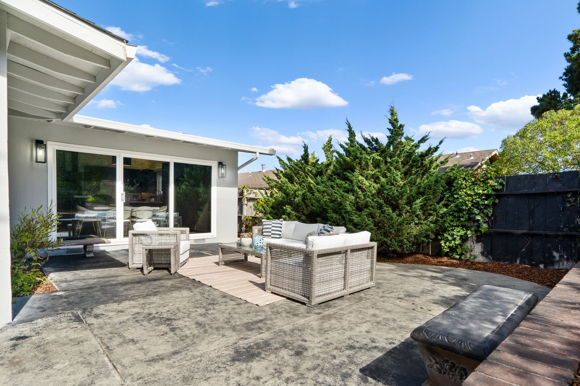 A patio with furniture and a bench.