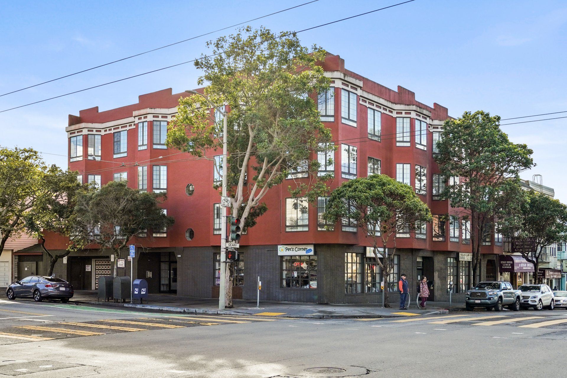 A large red building is sitting on the corner of a street.