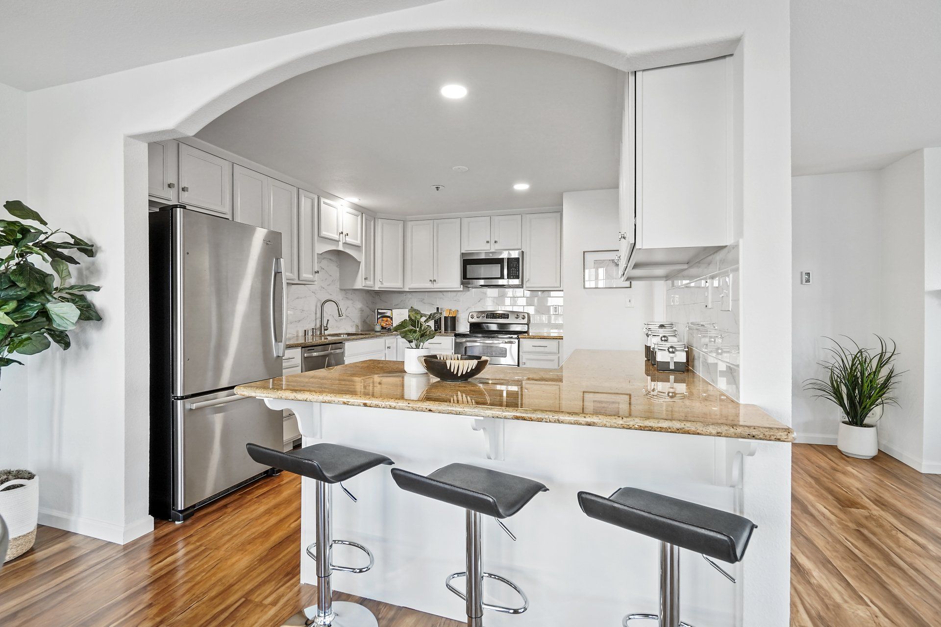 A kitchen with white cabinets and stainless steel appliances