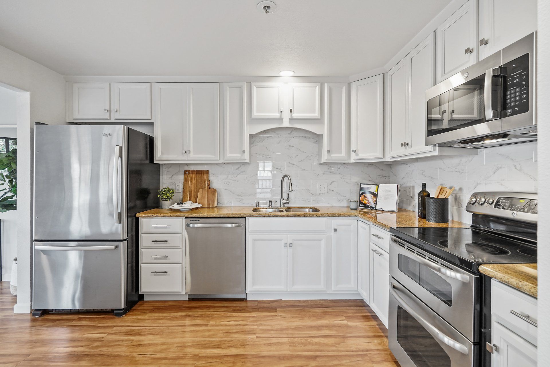 A kitchen with white cabinets and stainless steel appliances.