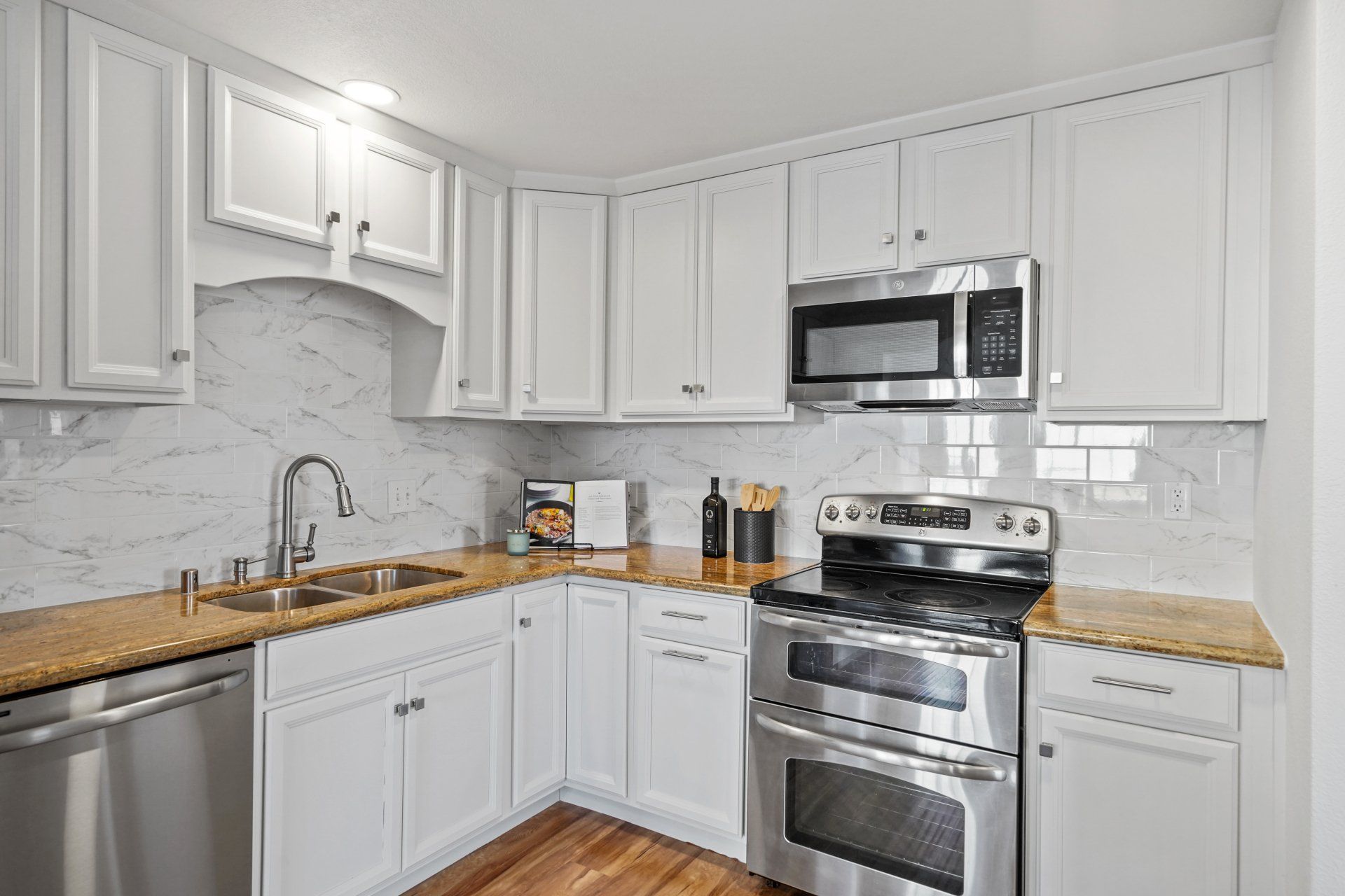 A kitchen with white cabinets and stainless steel appliances