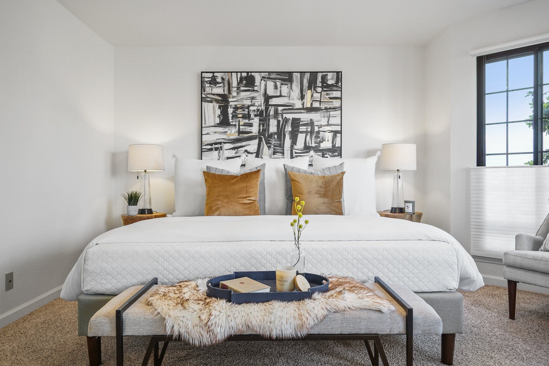 A bedroom with a bed and a bench.