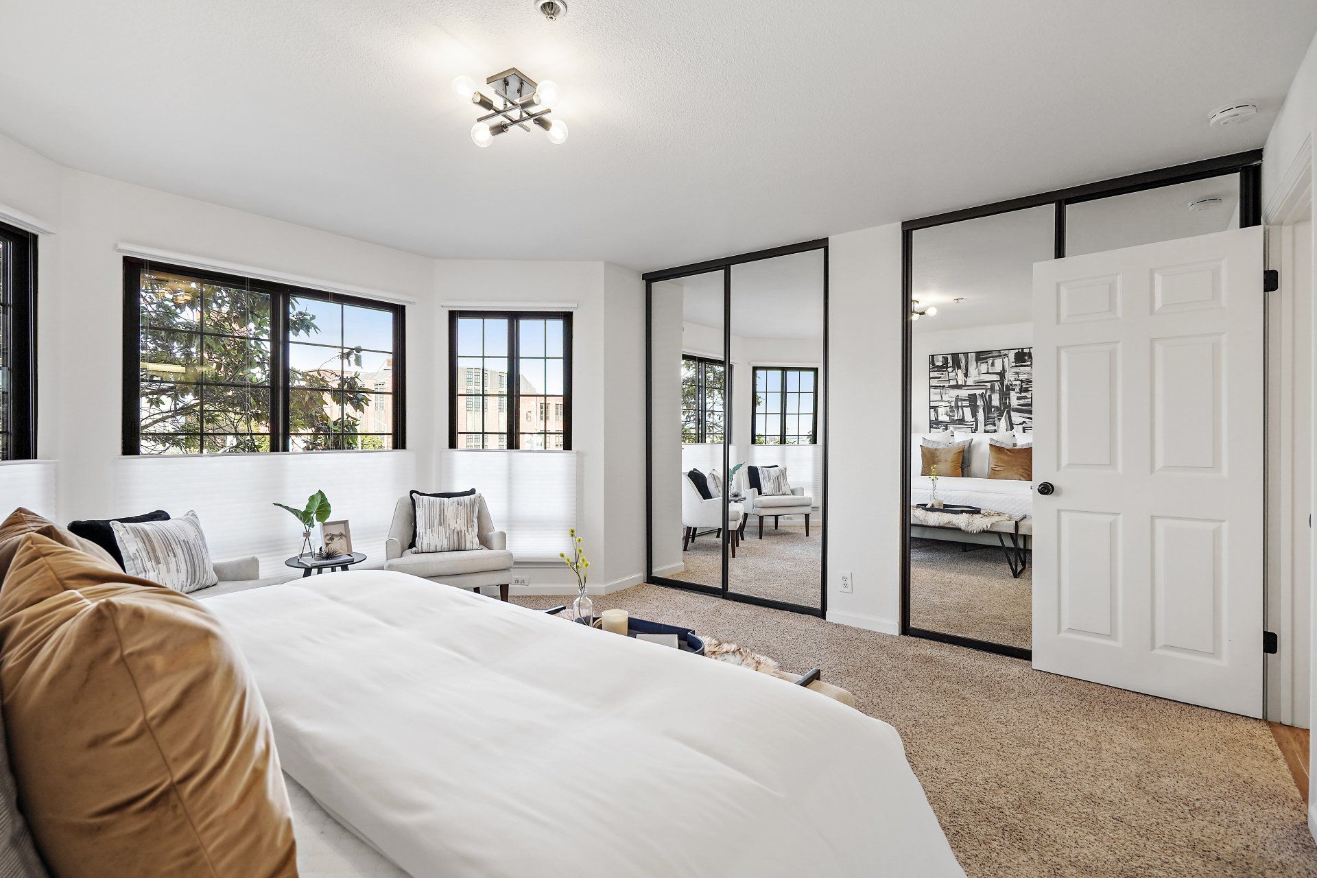 A bedroom with a large bed and lots of windows