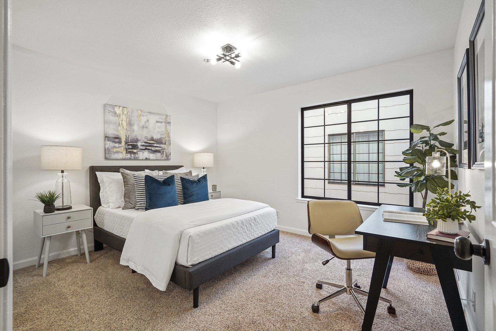 A bedroom with a bed , desk , chair and window.