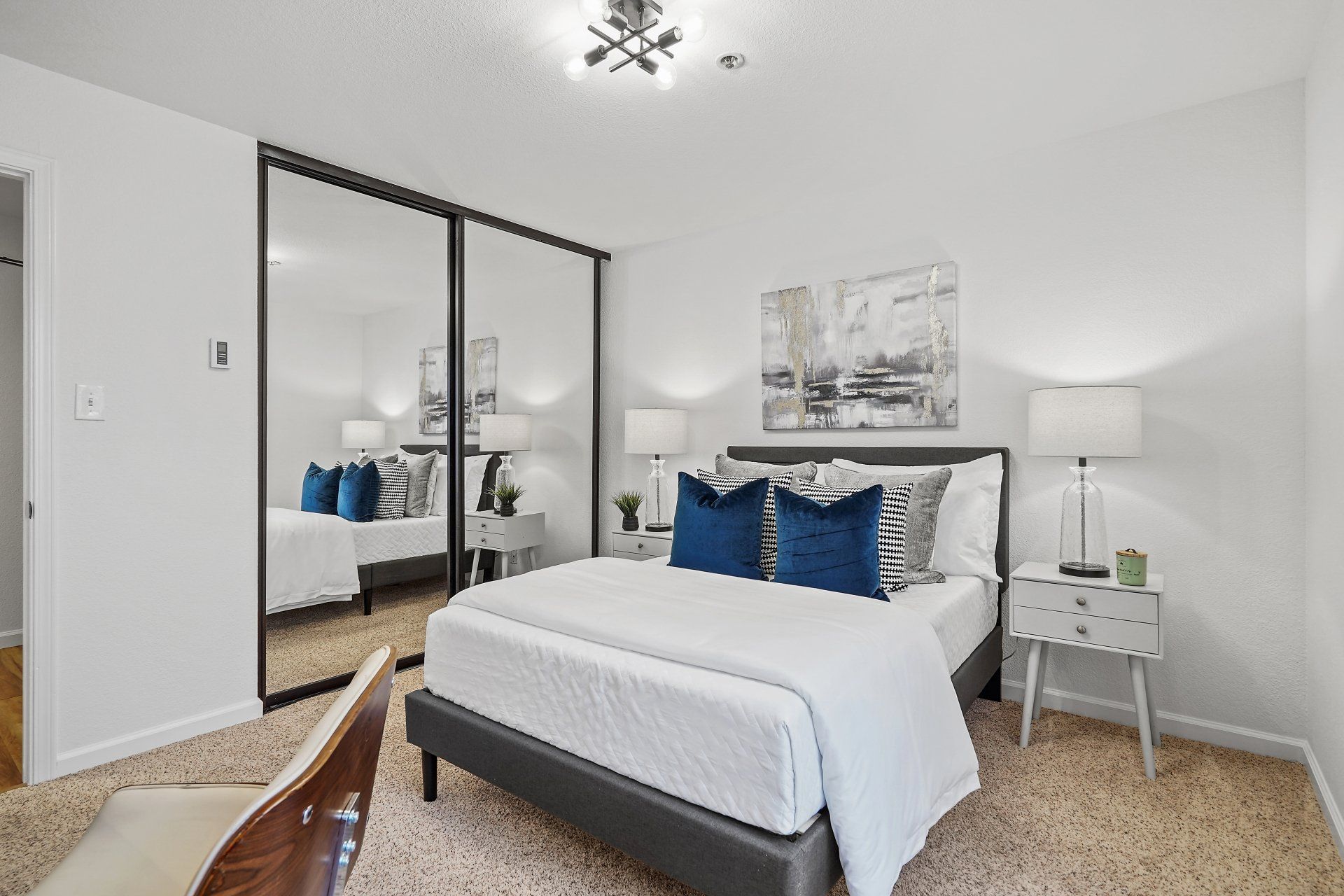 A bedroom with a large bed and sliding glass doors.