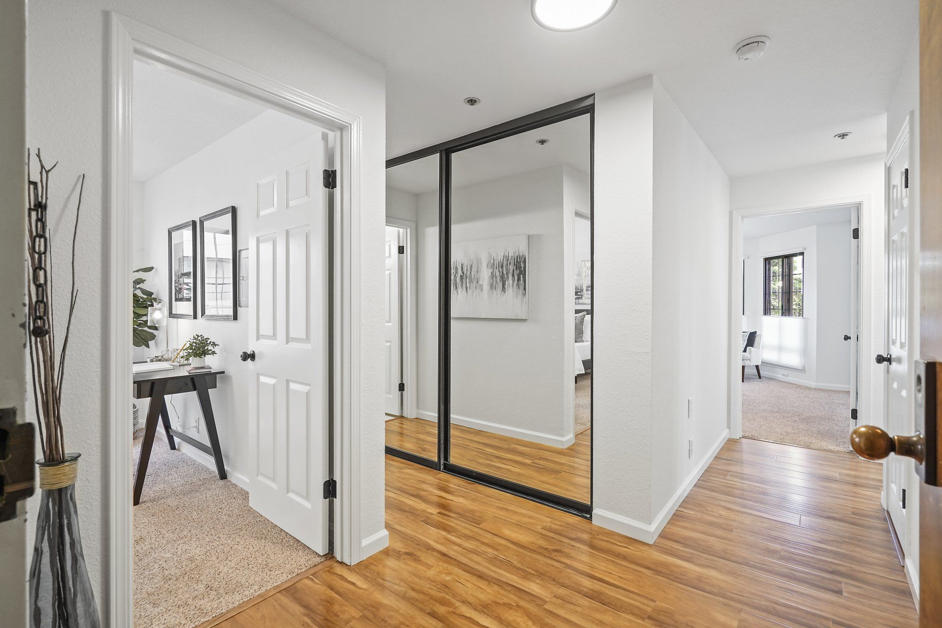 A hallway in a house with hardwood floors and sliding glass doors.