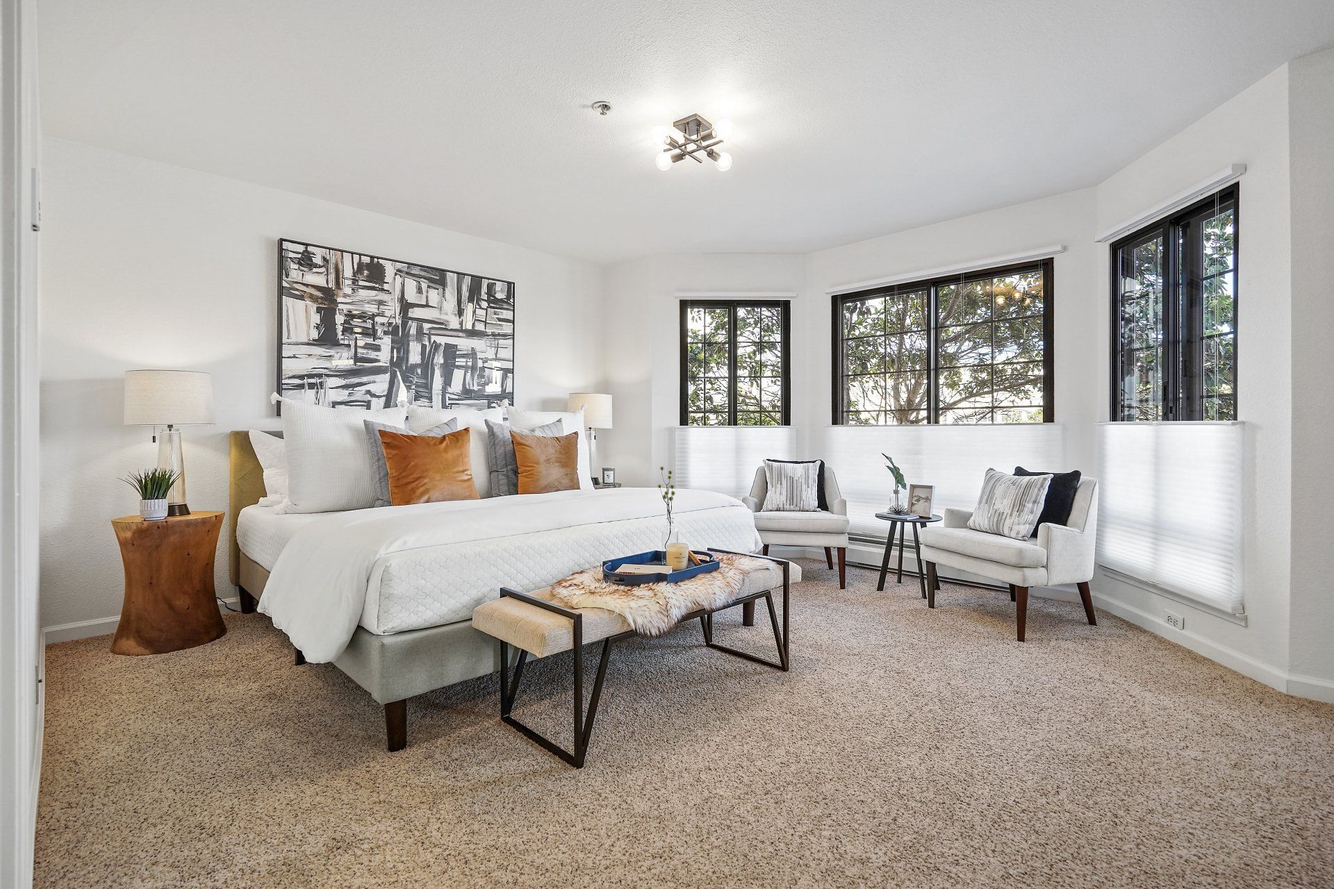 A bedroom with a bed , chairs , and a bench.