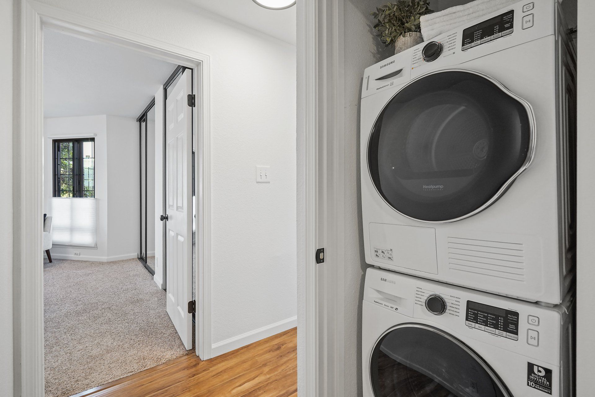 A washer and dryer are stacked on top of each other in a laundry room.