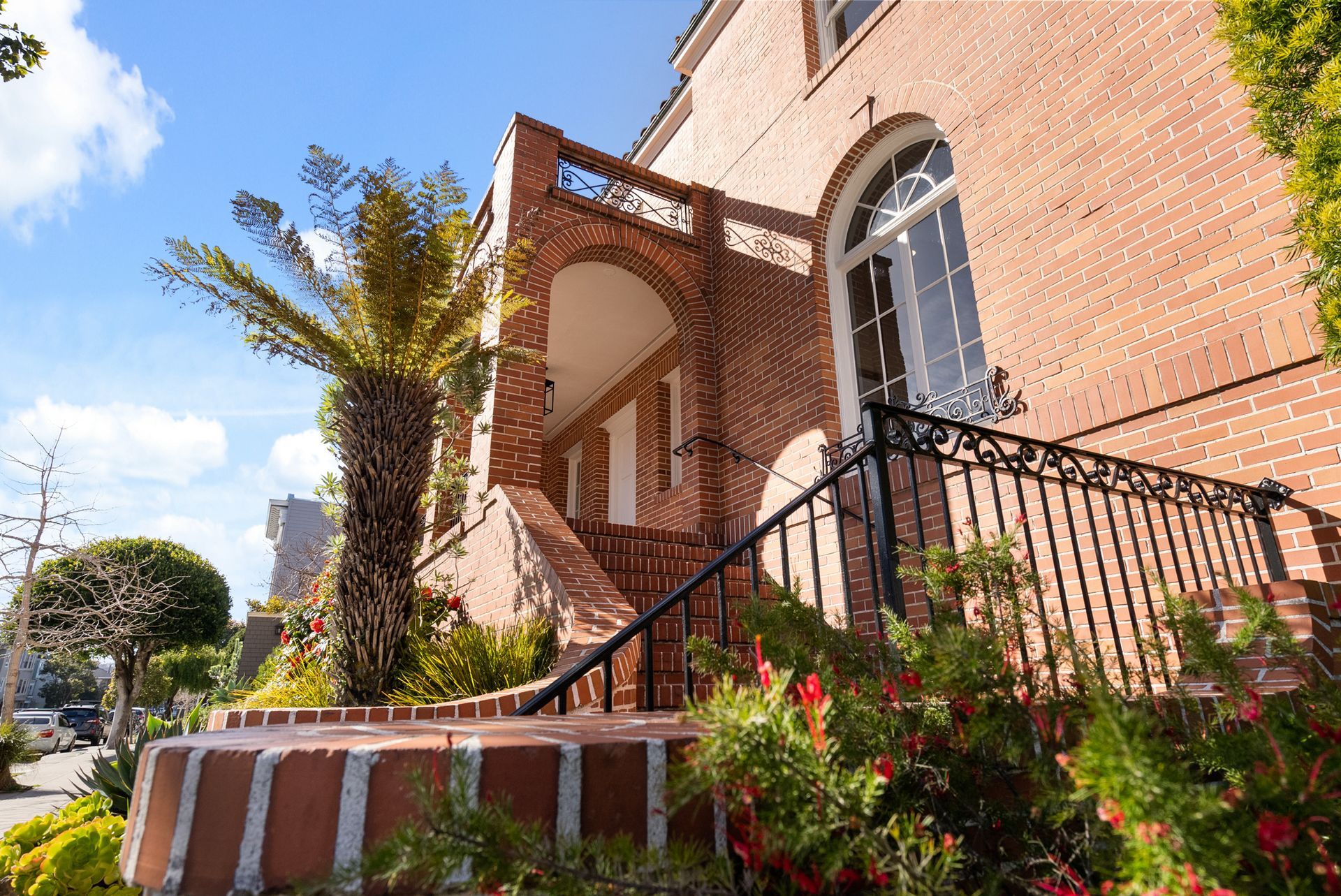 A brick building with stairs leading up to the front door