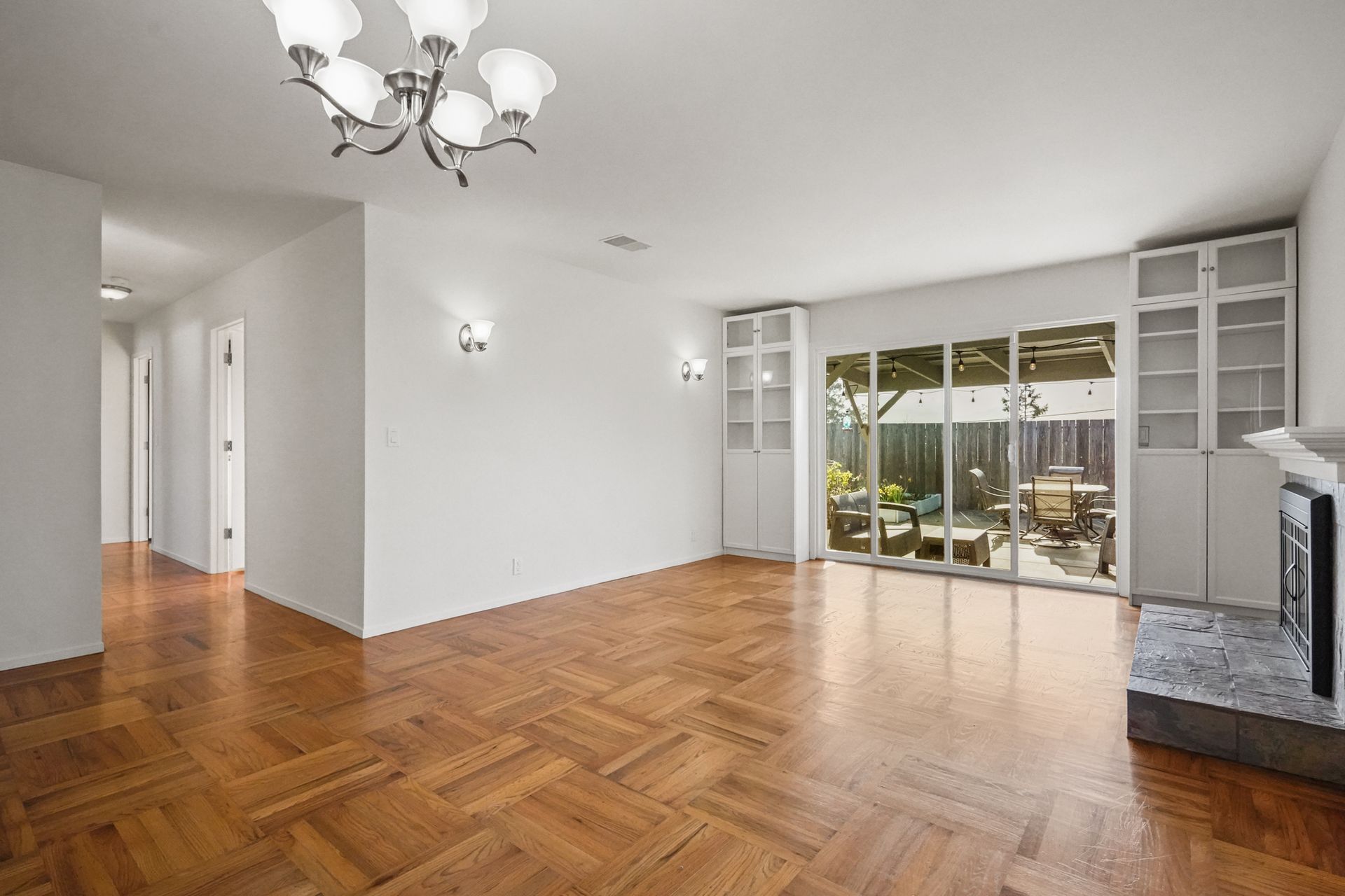 An empty living room with hardwood floors and a fireplace.