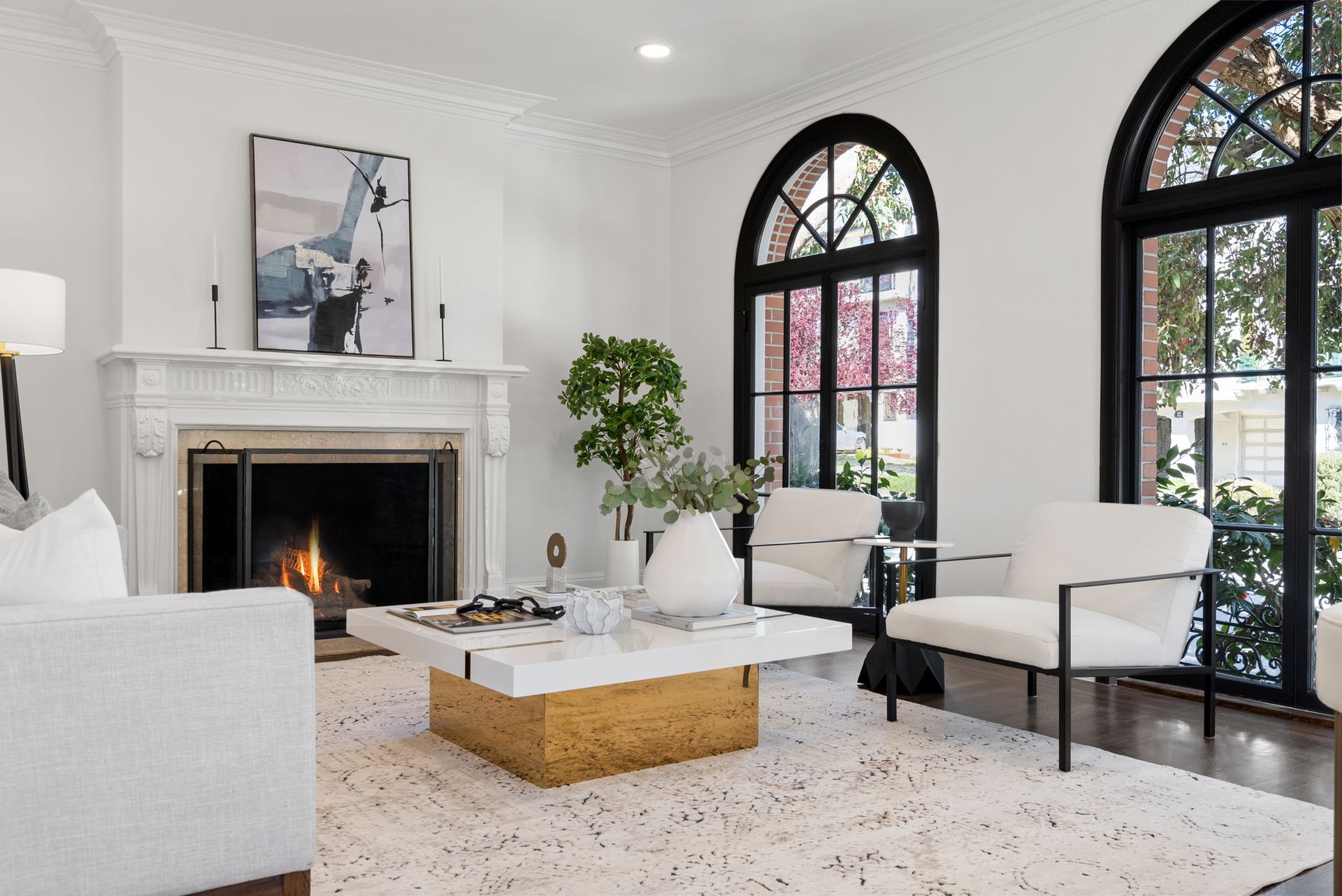 A living room with white furniture and a fireplace