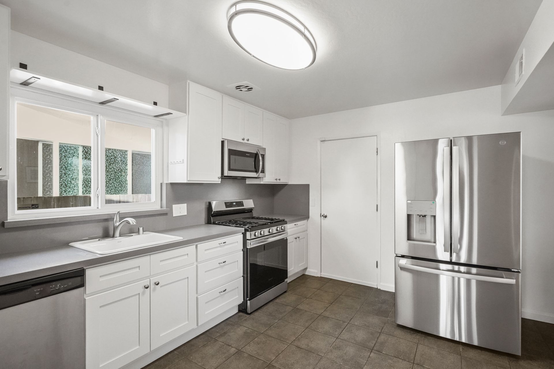 A kitchen with stainless steel appliances and white cabinets.