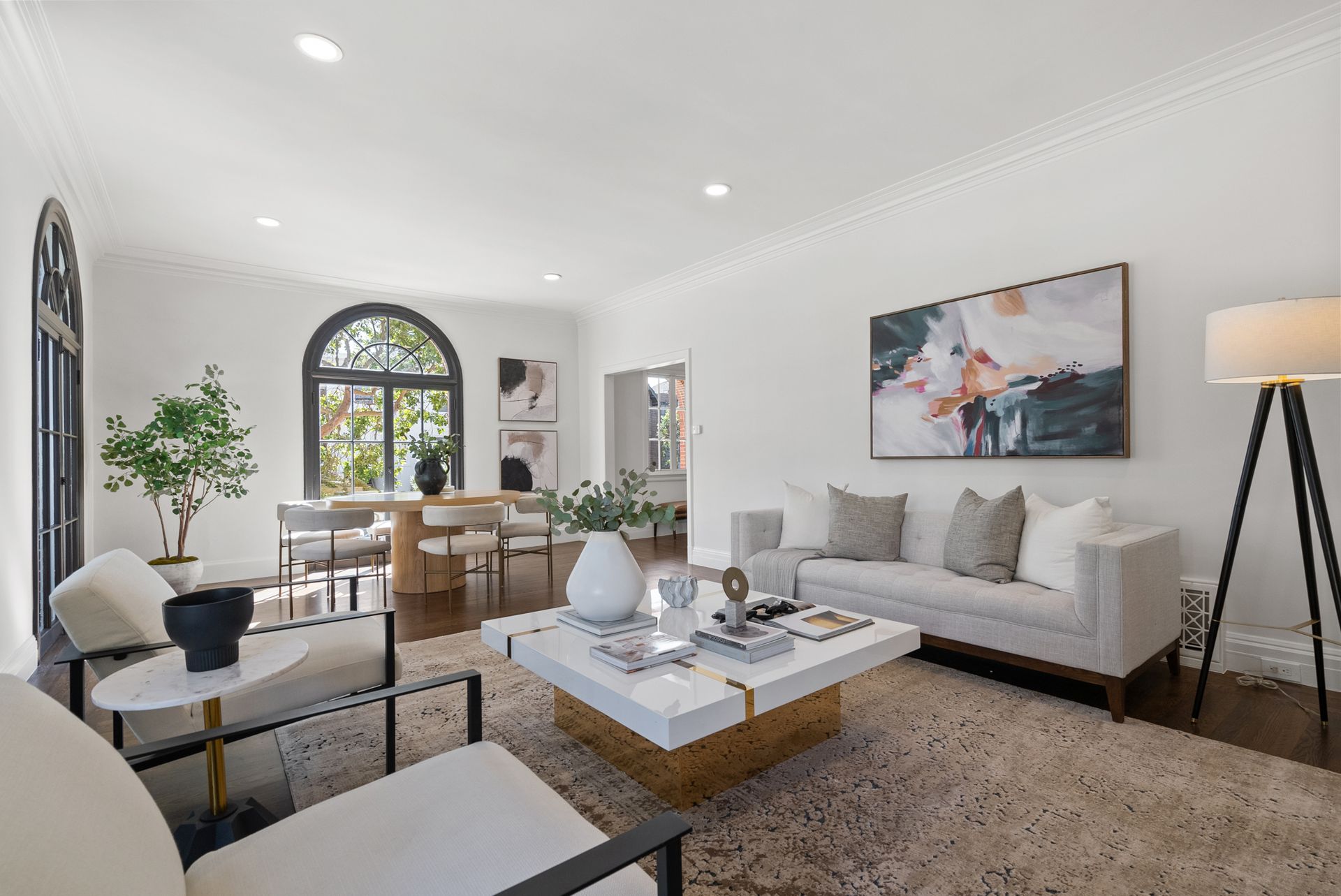 A living room with a couch , chair , coffee table and lamp.