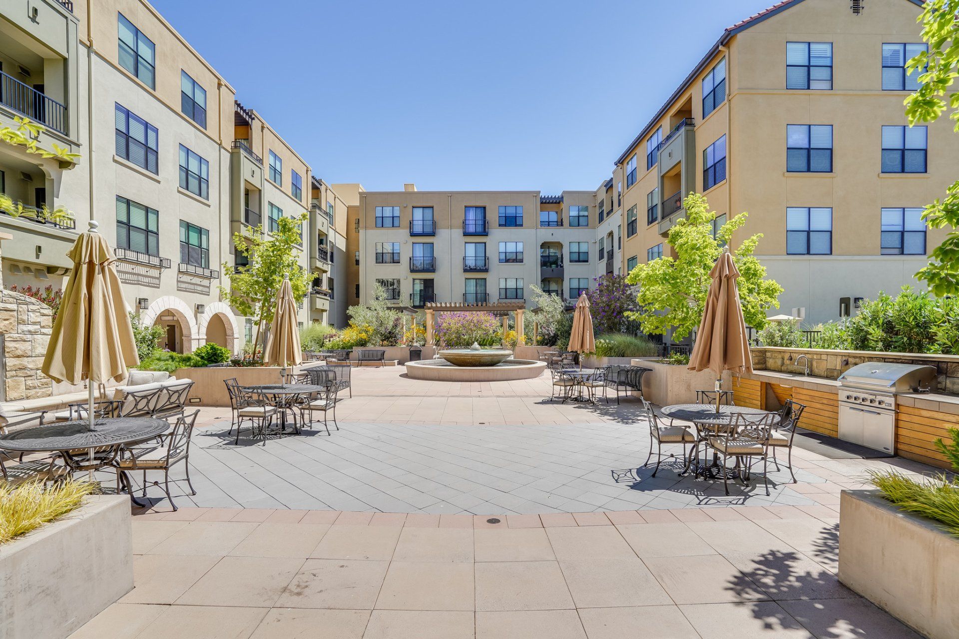 A large building with tables and chairs in front of it.