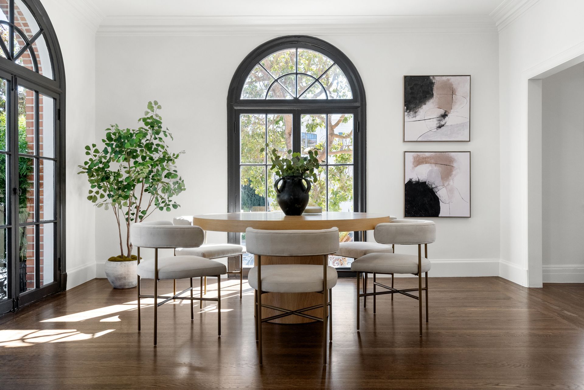 A dining room with a table and chairs and a large window.