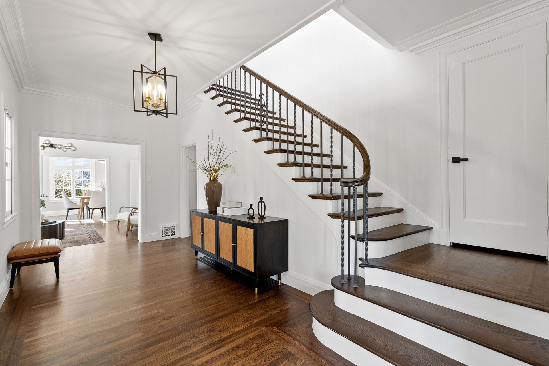 A wooden staircase in a hallway with white walls
