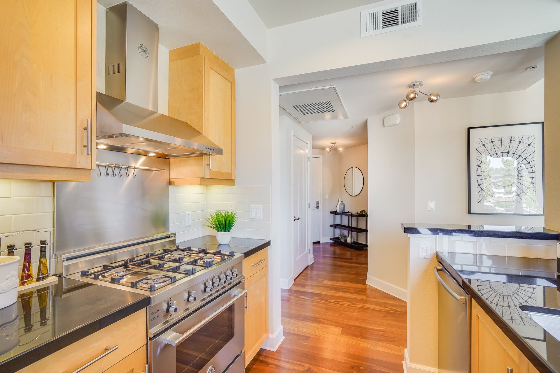 A kitchen with stainless steel appliances and wooden cabinets.