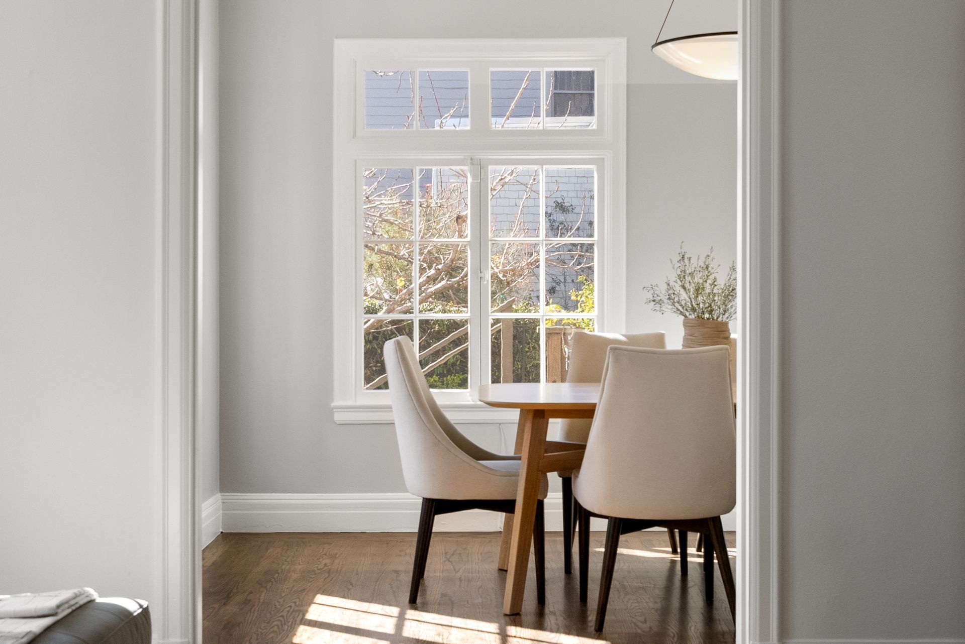 A dining room with a table and chairs and a window.