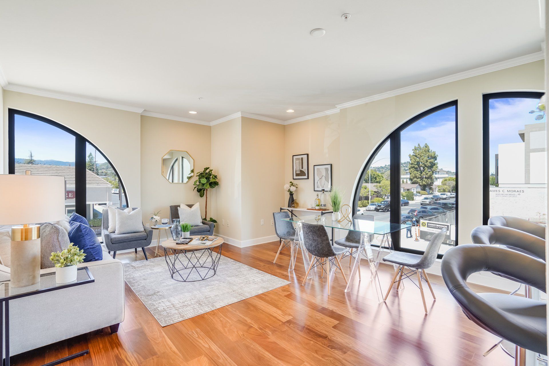 A living room with hardwood floors , a couch , a table and chairs.