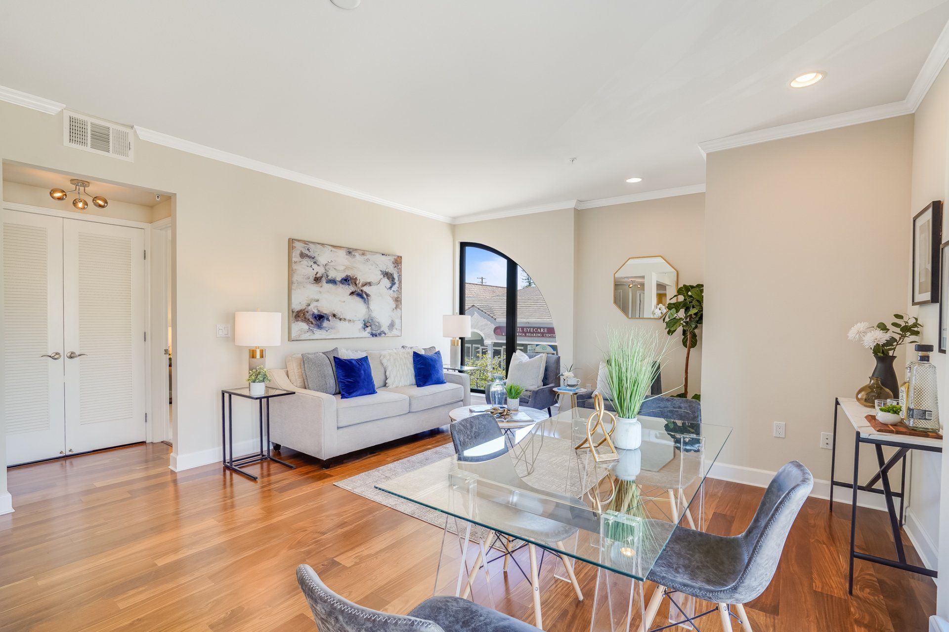 A living room with a glass dining table and chairs
