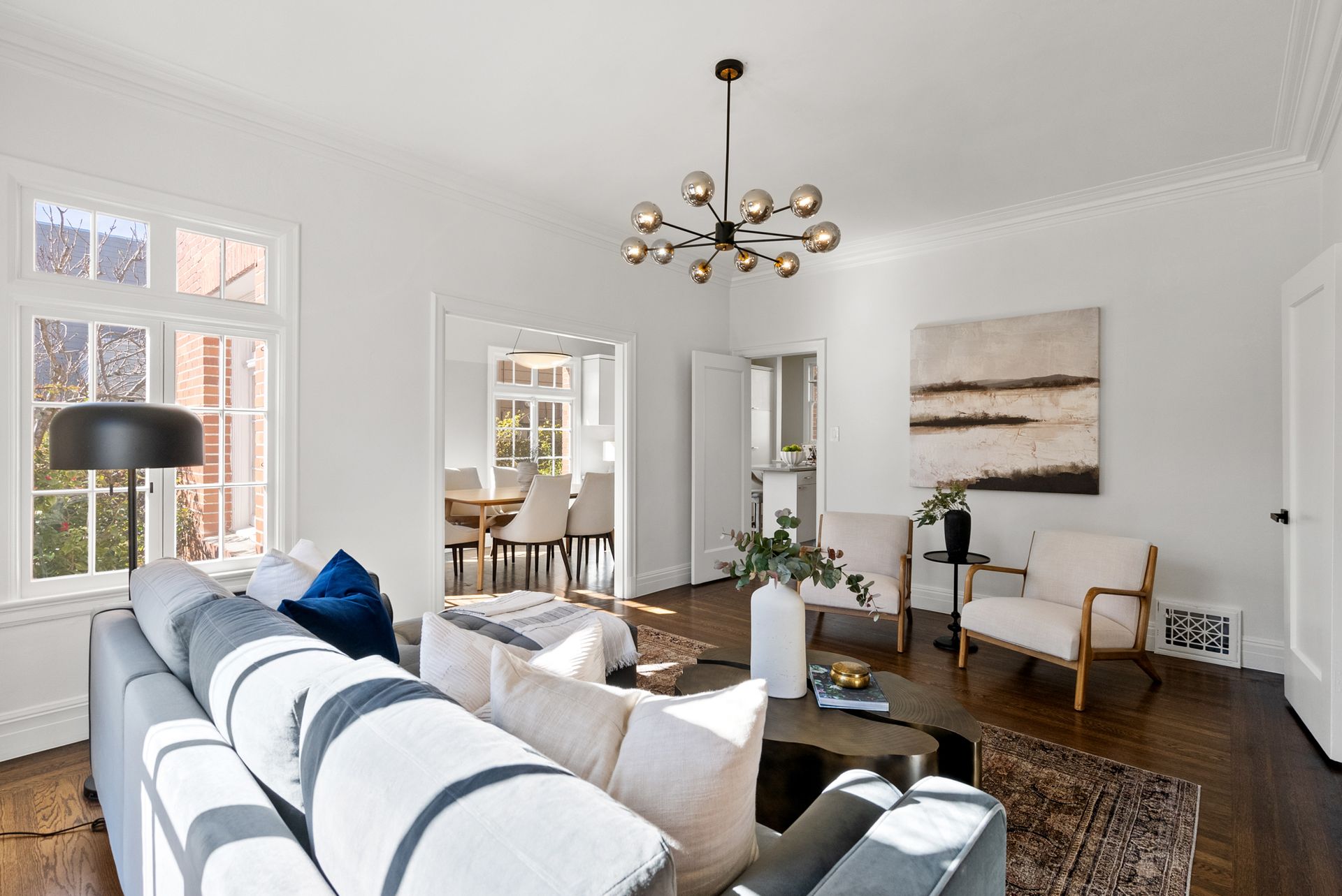A living room with a couch and chairs and a chandelier