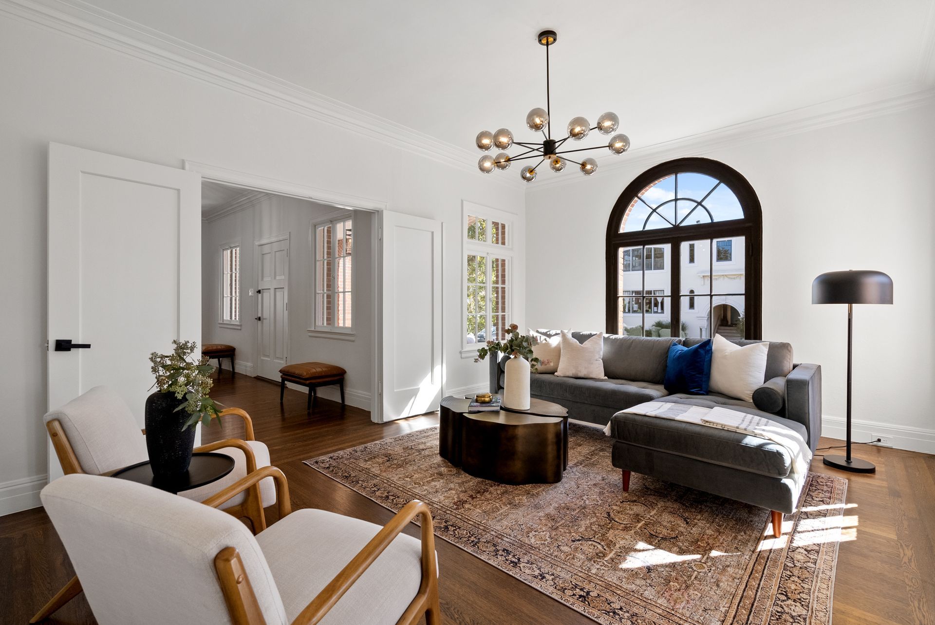 A living room with a couch , chairs , and a rug.