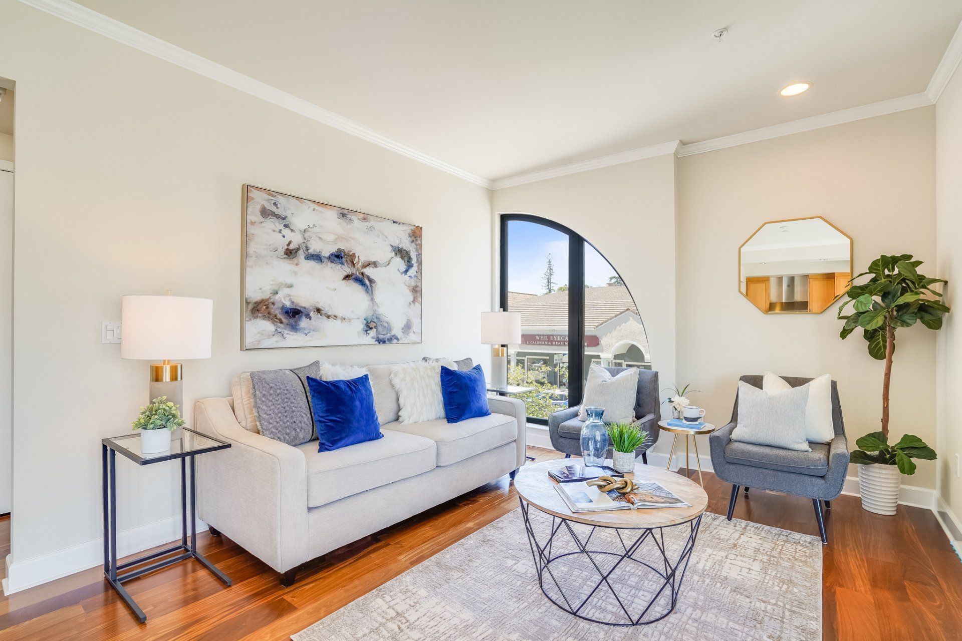A living room with a white couch and a round coffee table