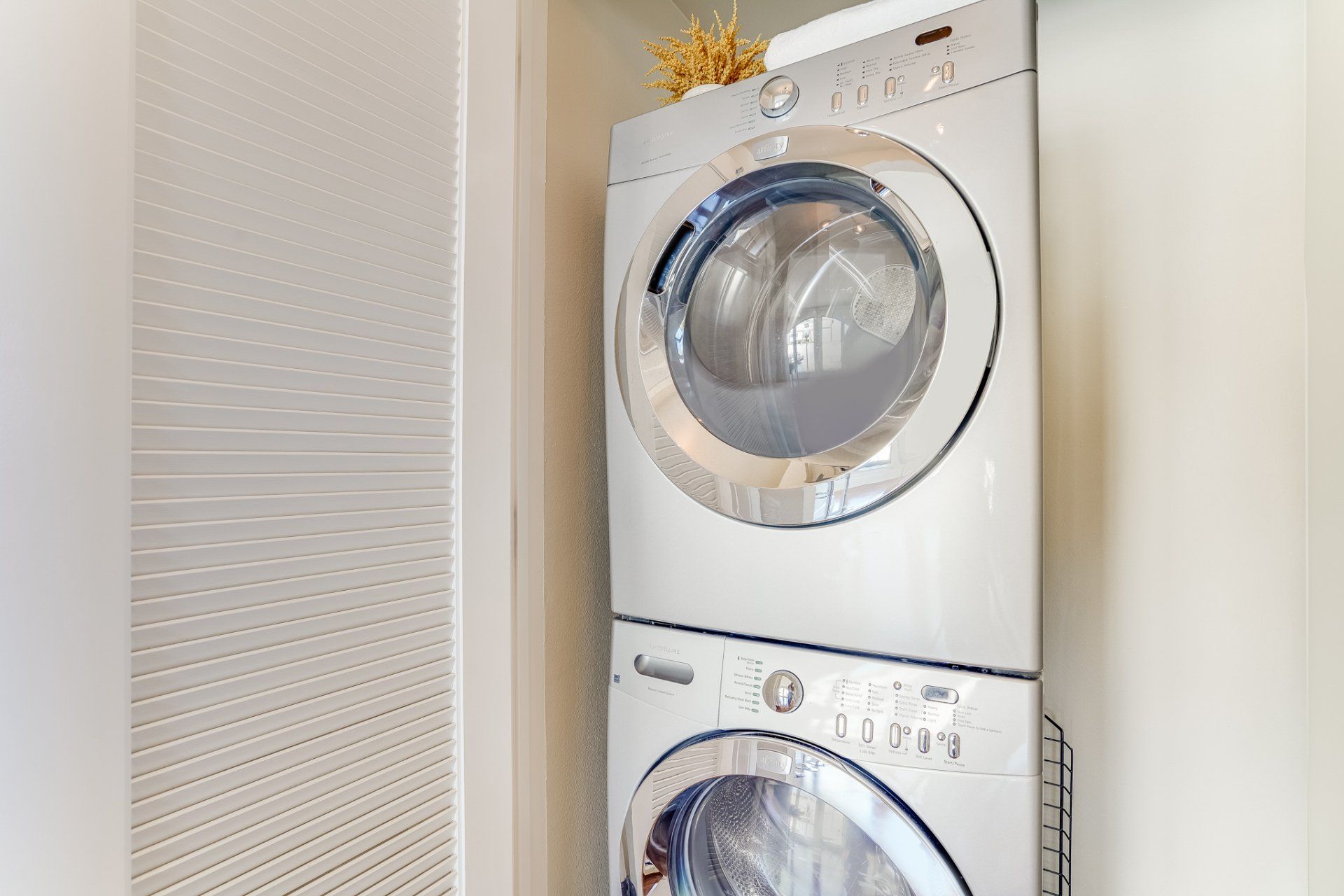 A washer and dryer are stacked on top of each other in a laundry room.