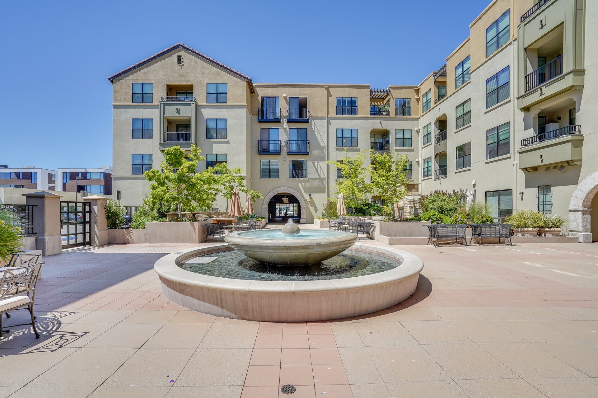 A large apartment building with a fountain in front of it.