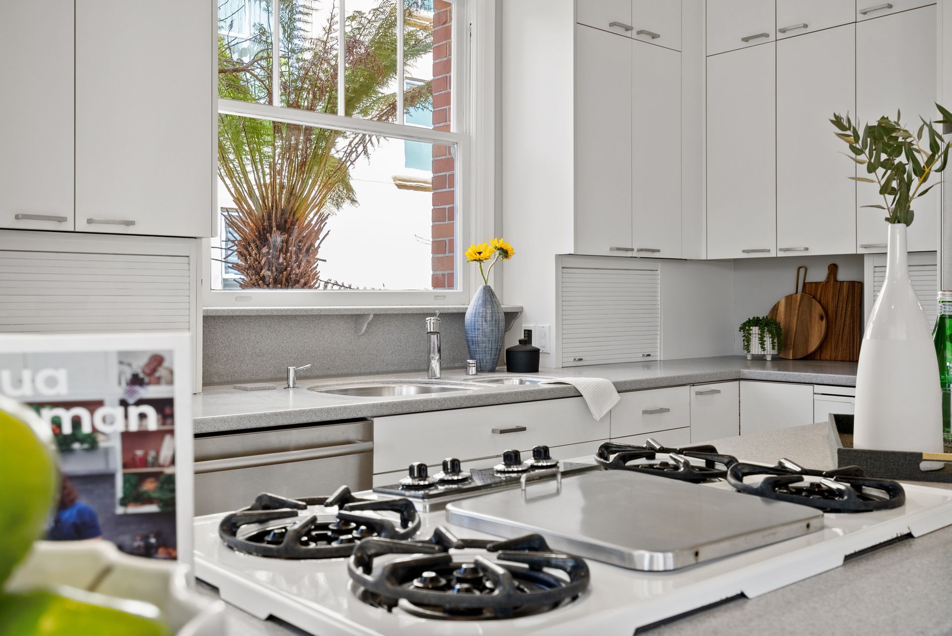 A kitchen with white cabinets and a stove top oven