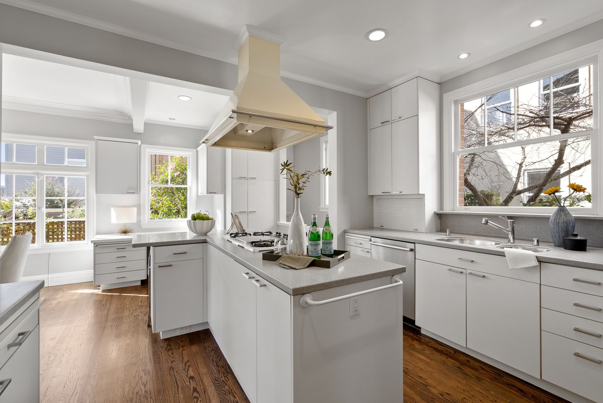 A kitchen with white cabinets and a large island in the middle