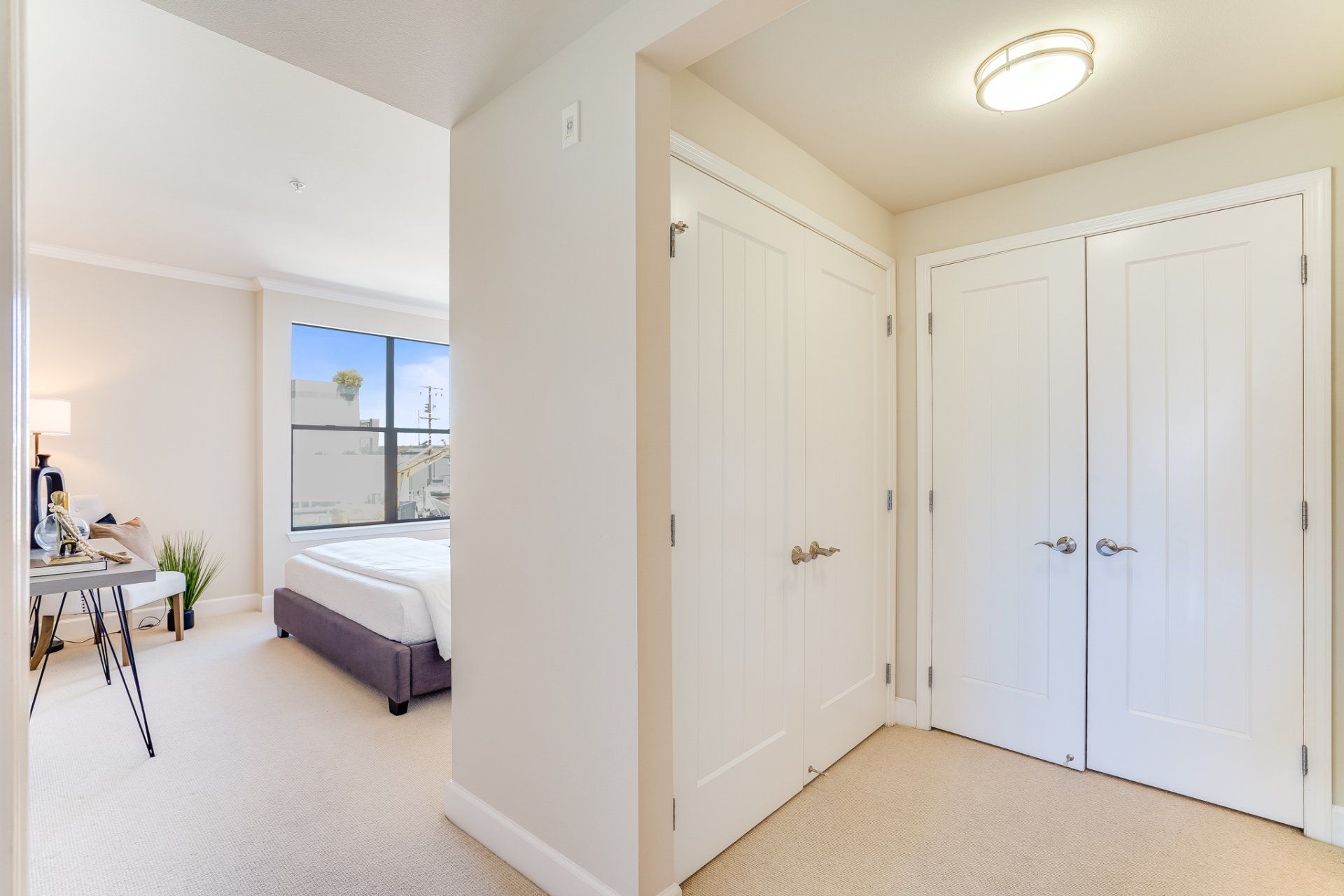 A hallway leading to a bedroom with a bed