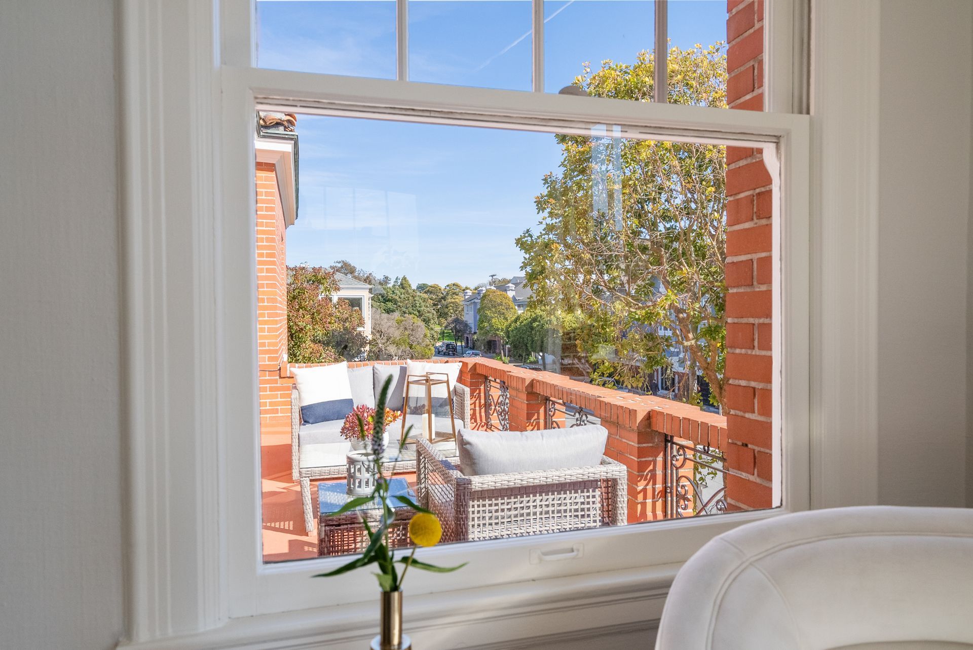 A bathroom with a bathtub and a window with a view of a balcony.