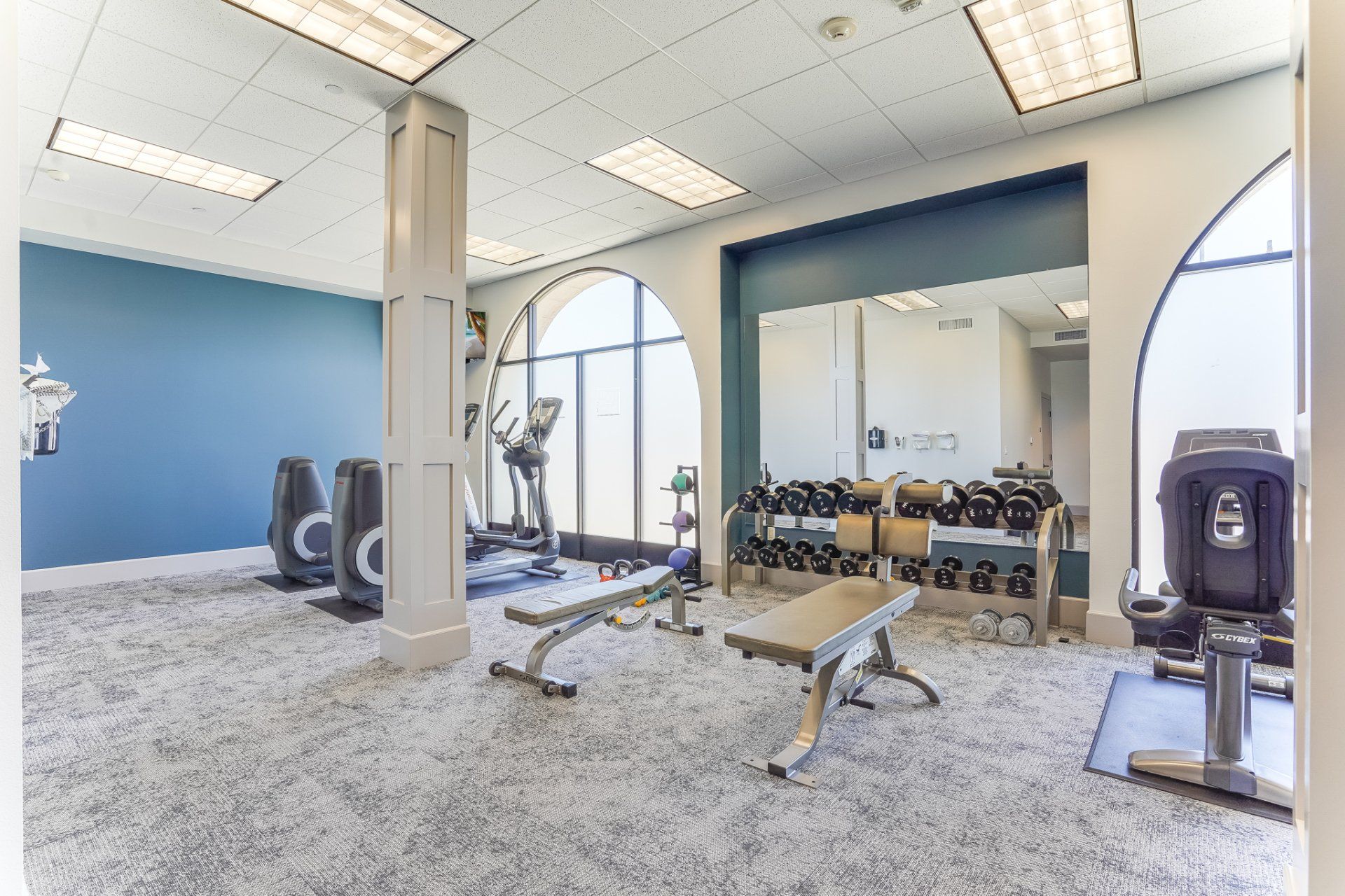 A gym with a lot of equipment and a bench