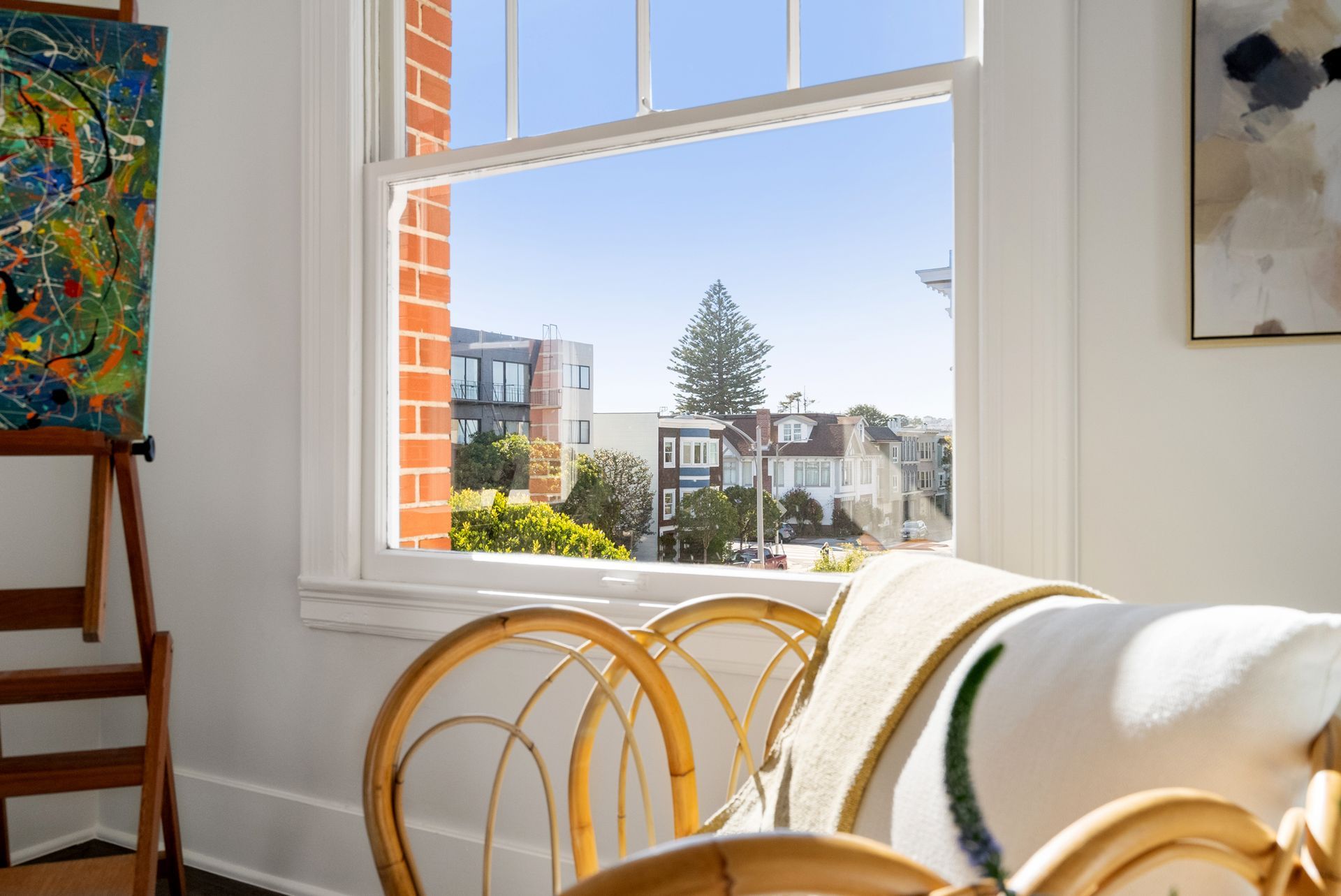 There is a painting on the easel in the corner of the room.