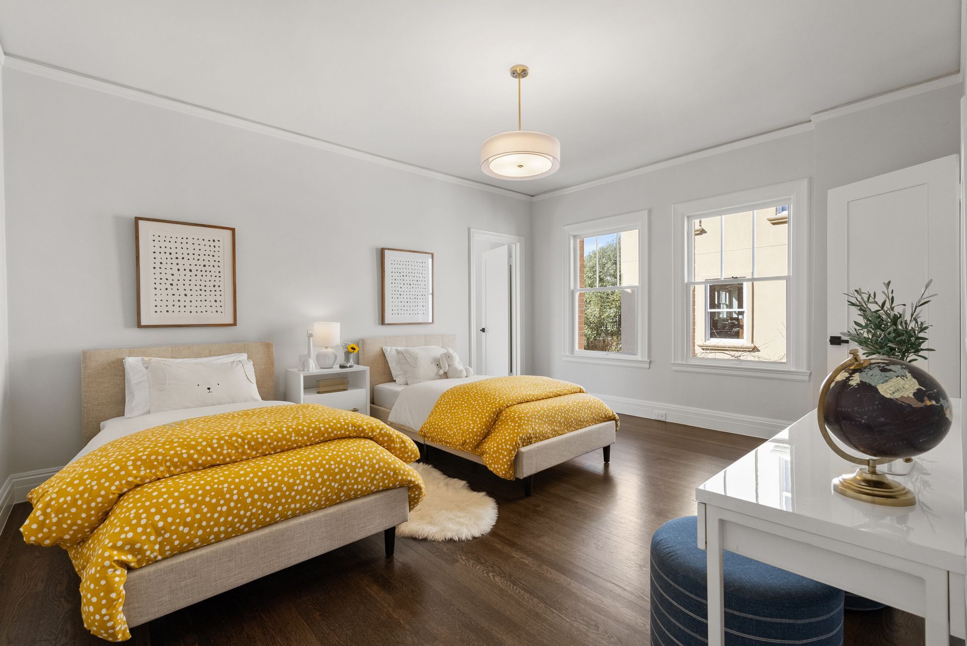 A bedroom with two beds and a desk