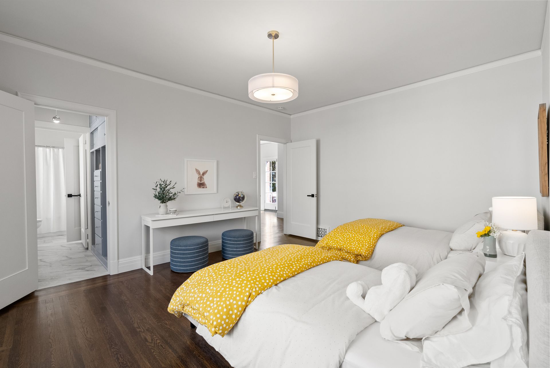 A bedroom with two beds and a desk