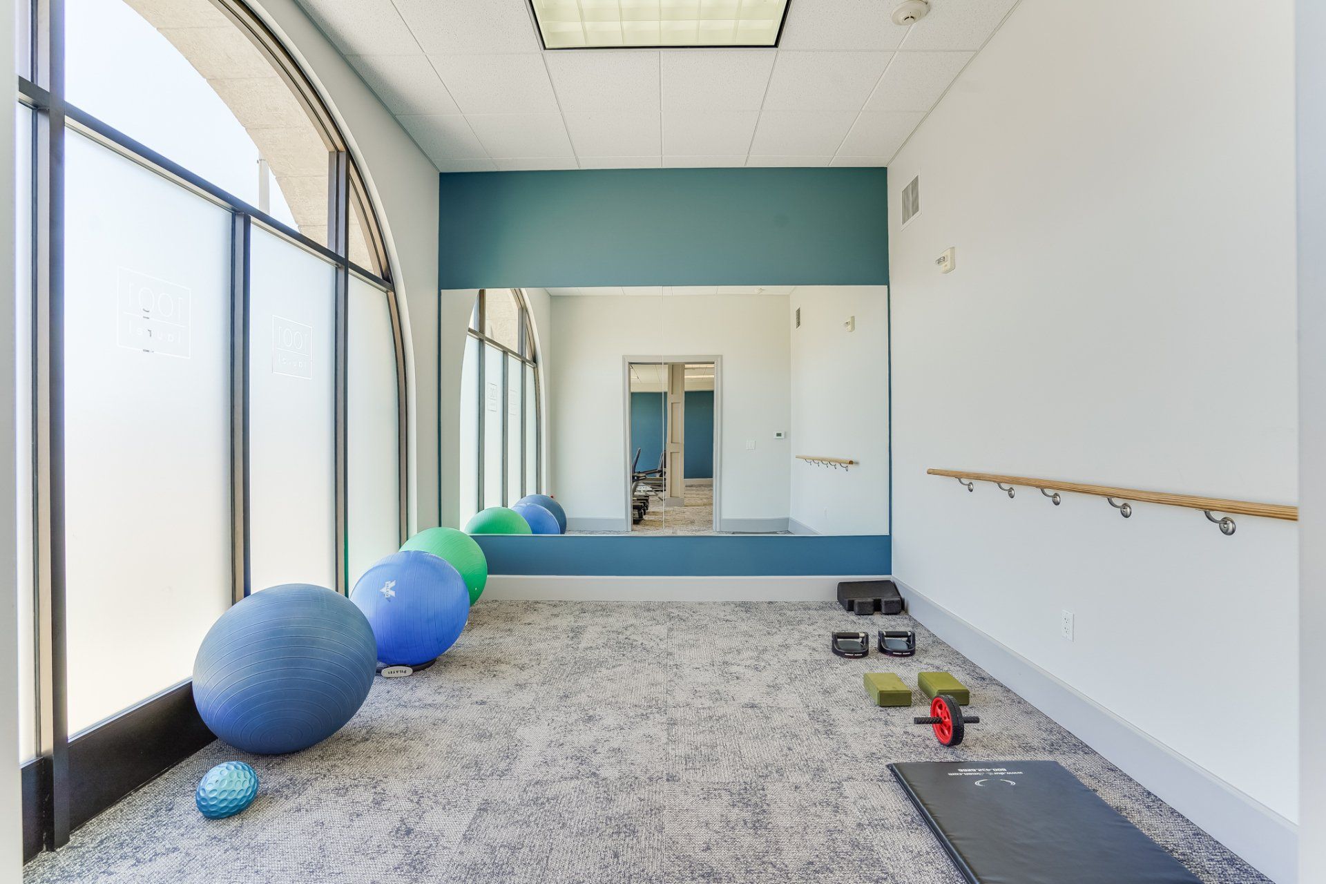 A gym with exercise balls and a mirror