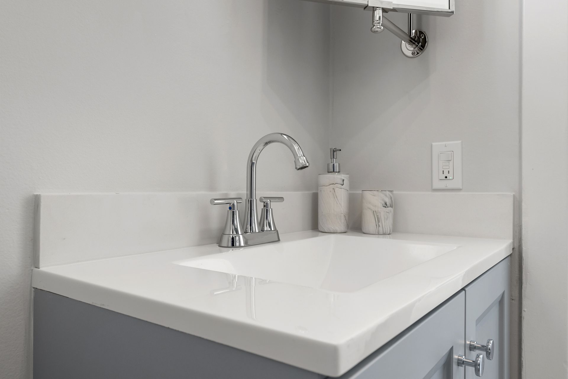 A bathroom sink with a faucet and soap dispenser on it.